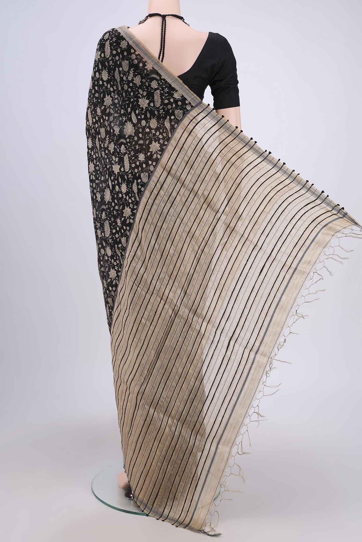 Flat view of Black Tussar Silk Saree with Printed design on the body and Plain Border. 