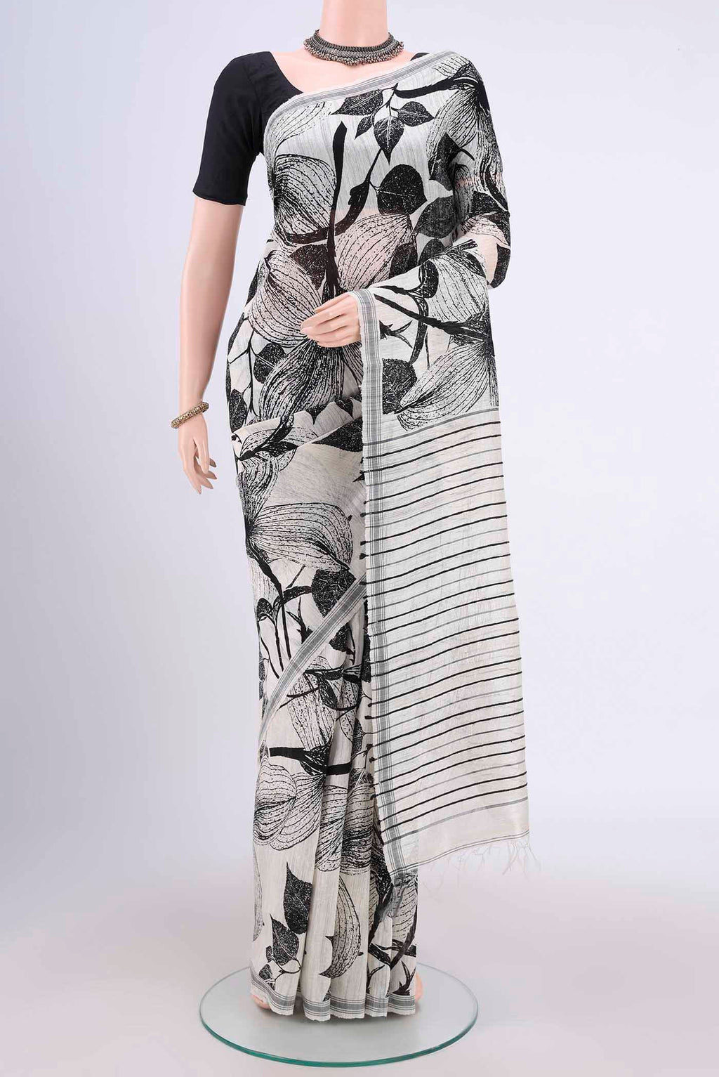 White Tussar Silk Saree with Printed design on the body and Plain Border.  displayed on a mannequin
