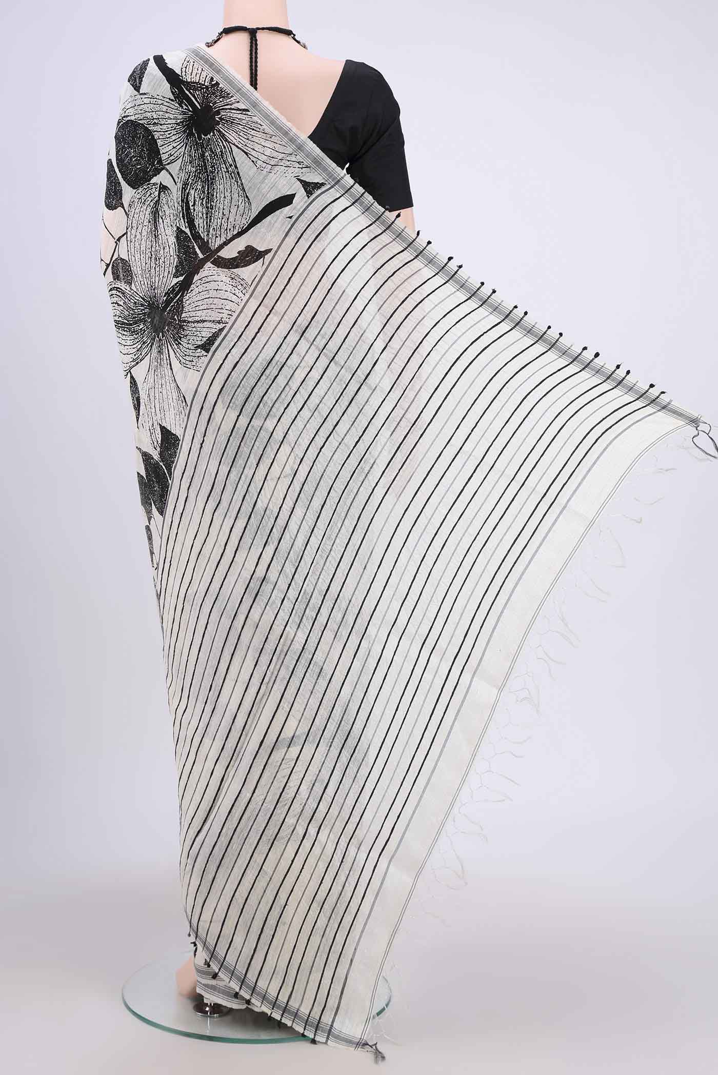 Flat view of White Tussar Silk Saree with Printed design on the body and Plain Border. 