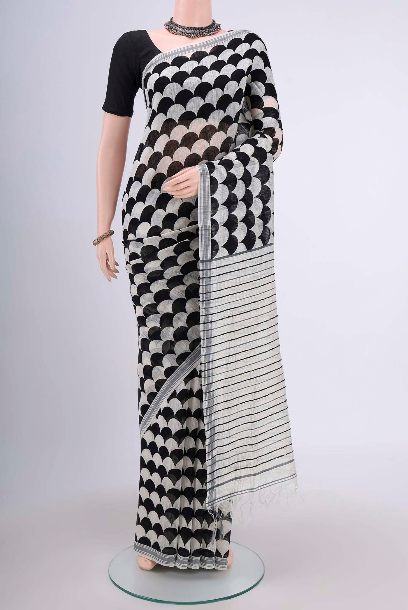 Black Tussar Silk Saree with Printed design on the body and Plain Border.  displayed on a mannequin