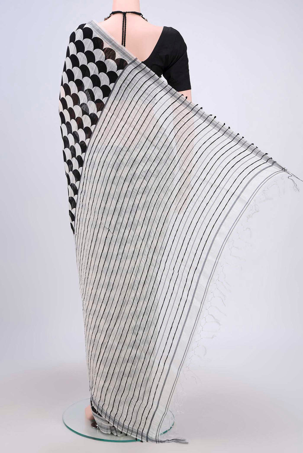 Flat view of Black Tussar Silk Saree with Printed design on the body and Plain Border. 