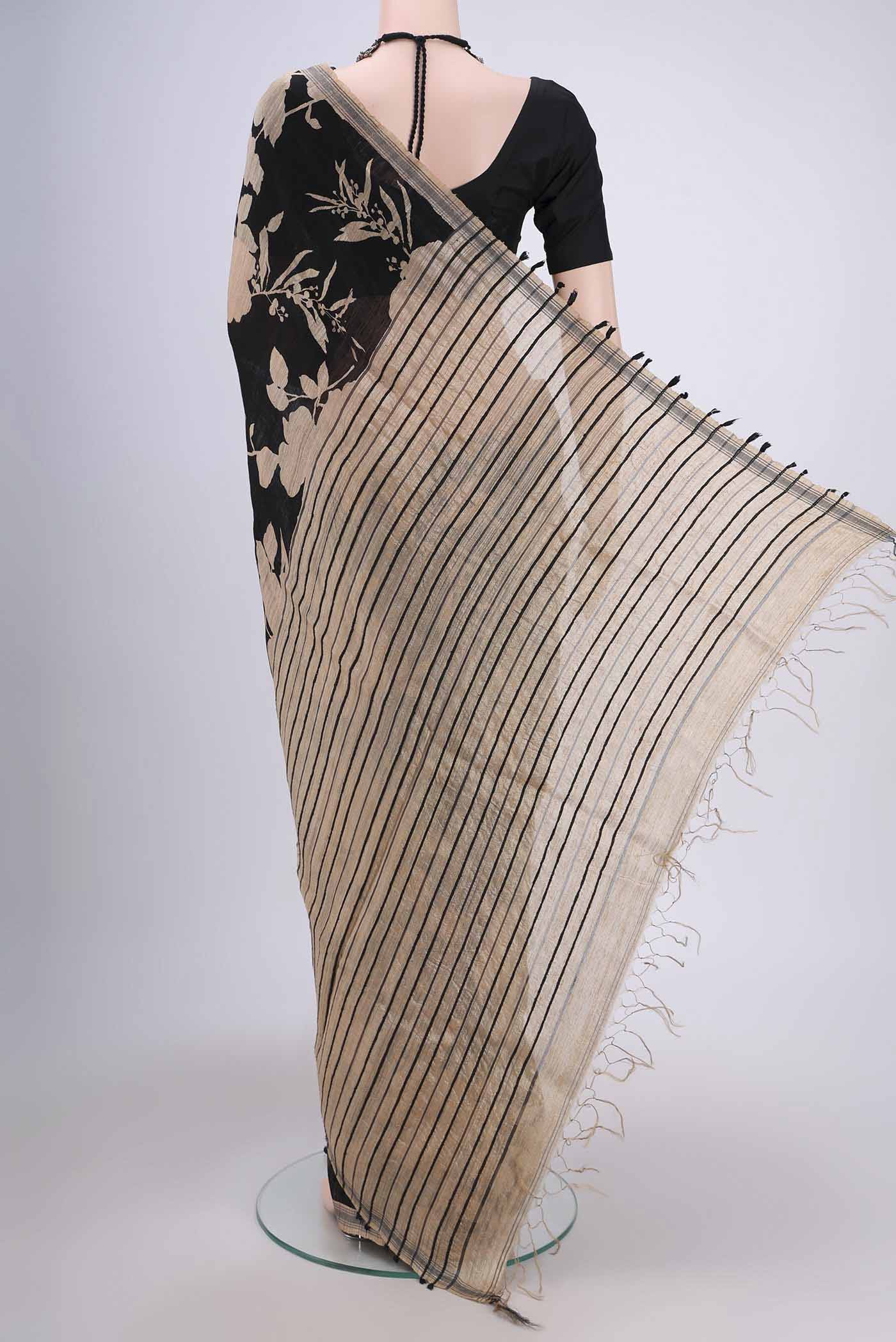 Flat view of Black Tussar Silk Saree with Printed design on the body and Plain Border. 