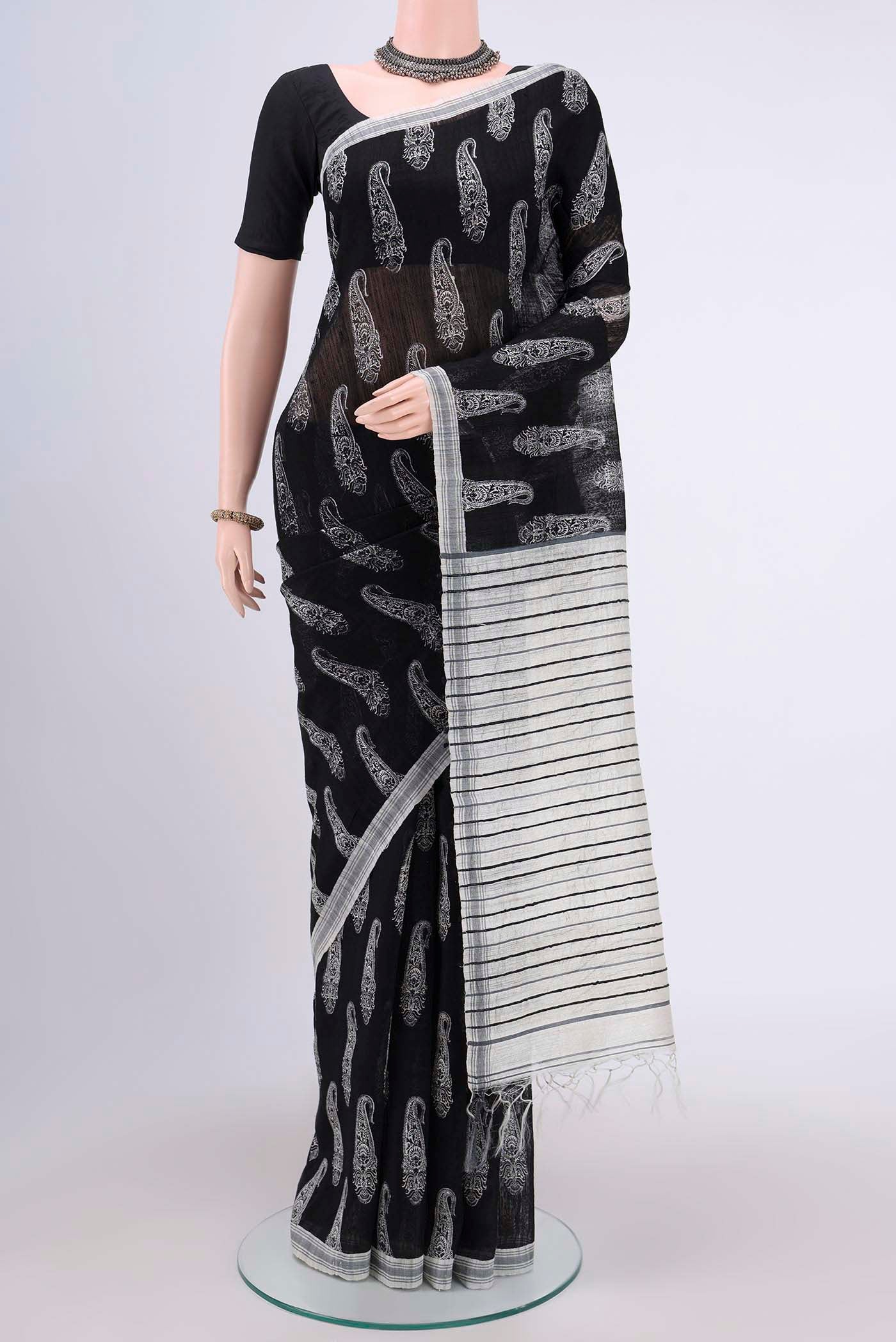 Black Tussar Silk Saree with Printed design on the body and Plain Border.  displayed on a mannequin