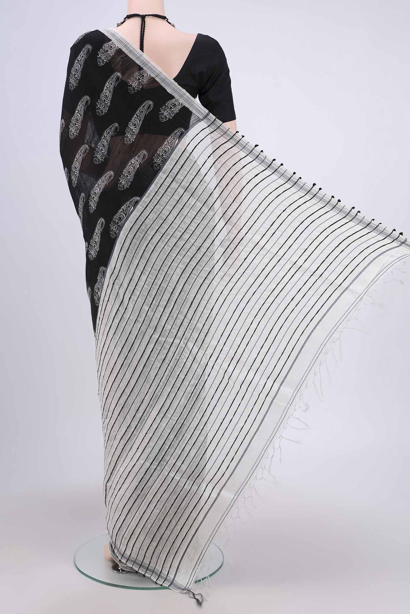 Flat view of Black Tussar Silk Saree with Printed design on the body and Plain Border. 