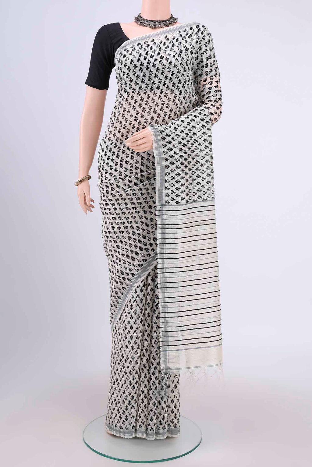 White Tussar Silk Saree with Printed design on the body and Plain Border.  displayed on a mannequin