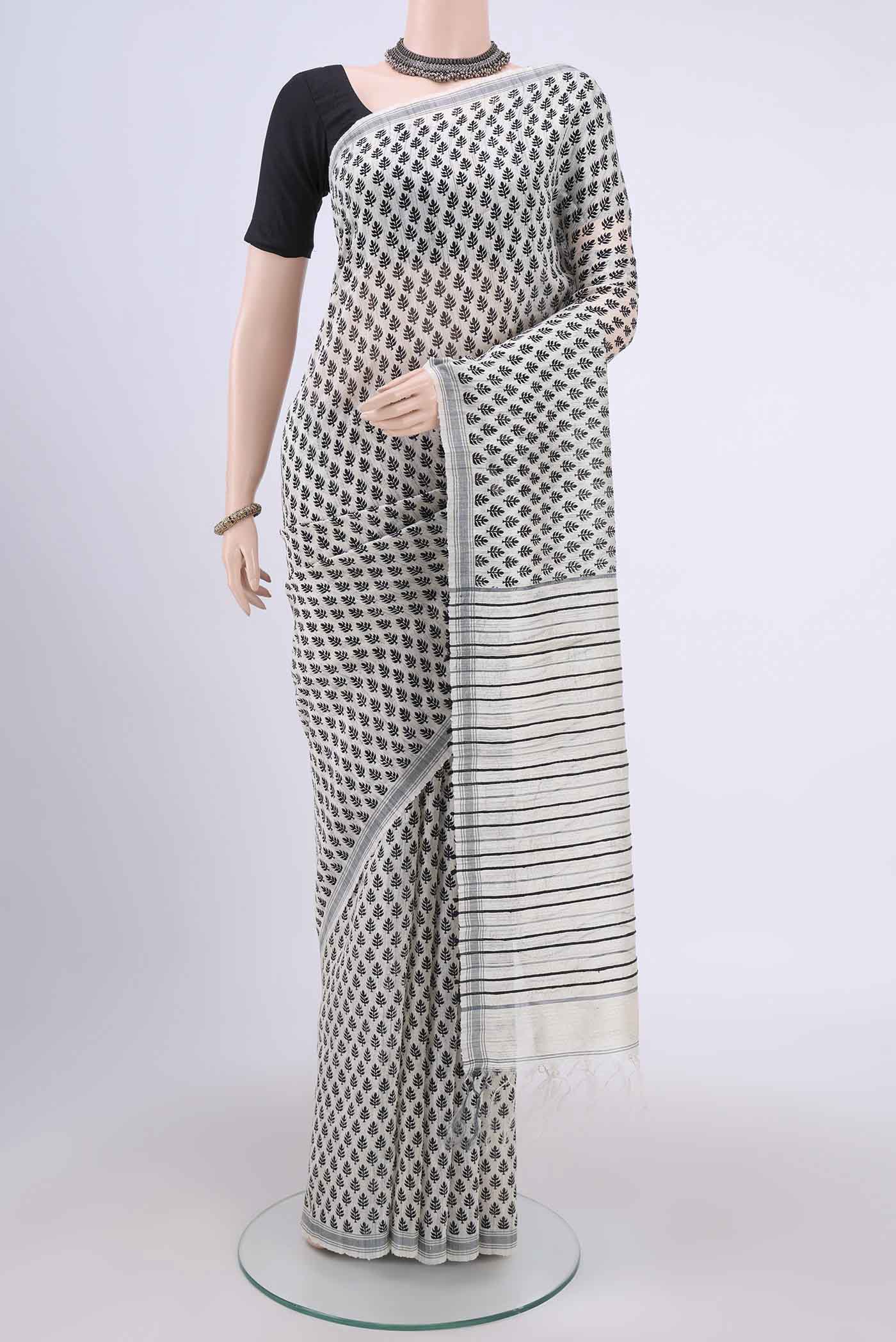 White Tussar Silk Saree with Printed design on the body and Plain Border.  displayed on a mannequin