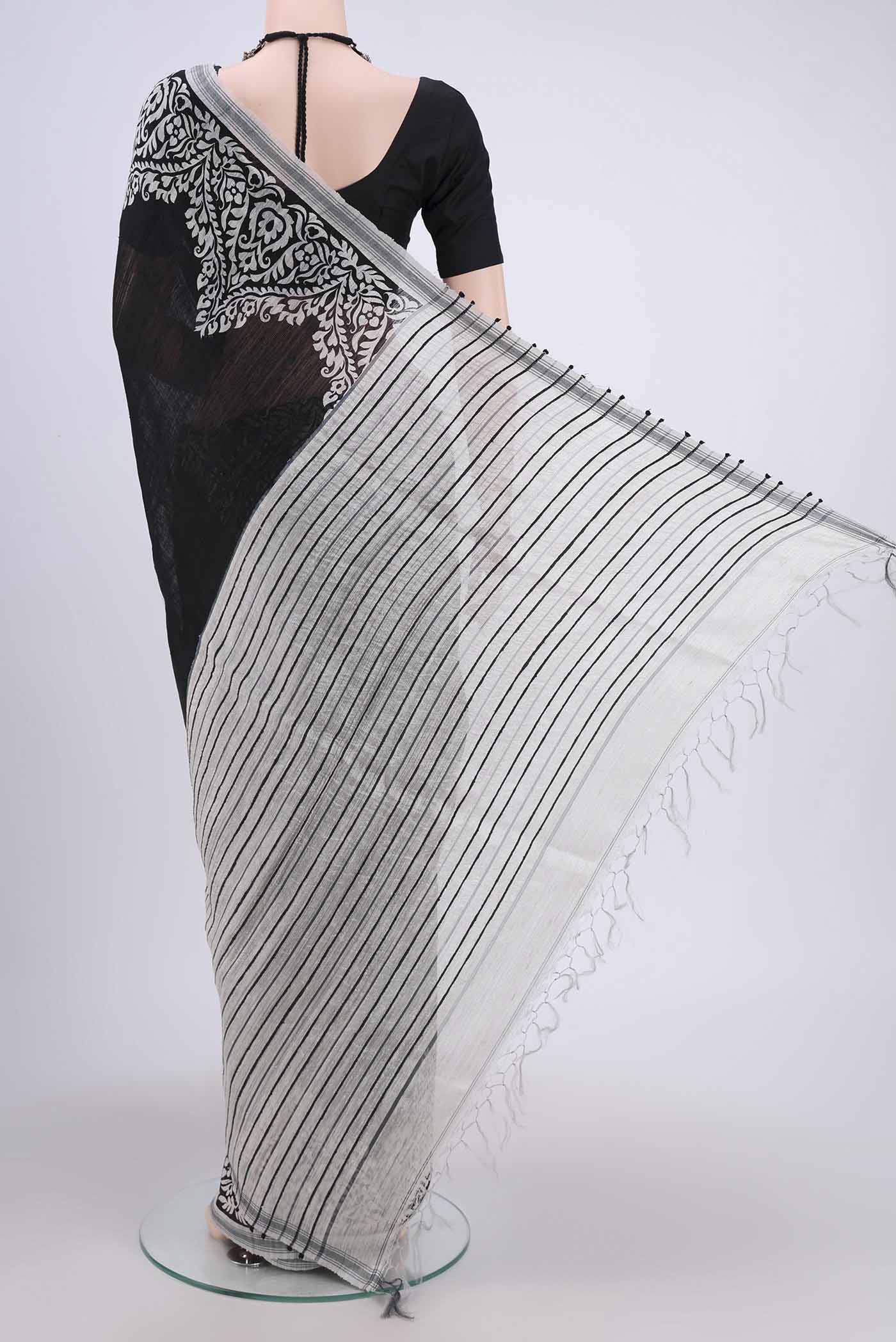 Flat view of Black Tussar Silk Saree with Printed design on the body and Plain Border. 