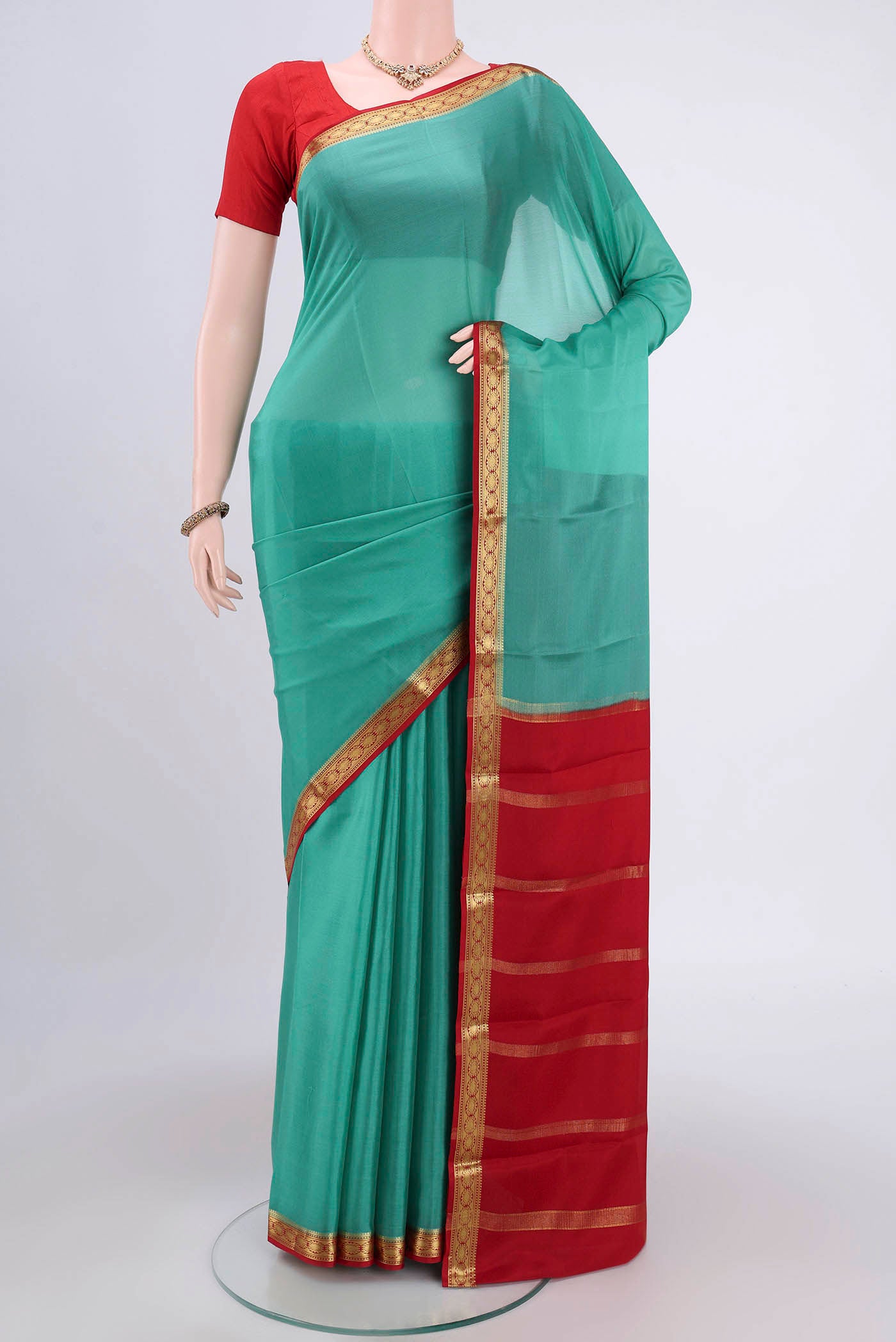 Sea Green Mysore Crepe Saree with Plain Body and Zari Border.  displayed on a mannequin