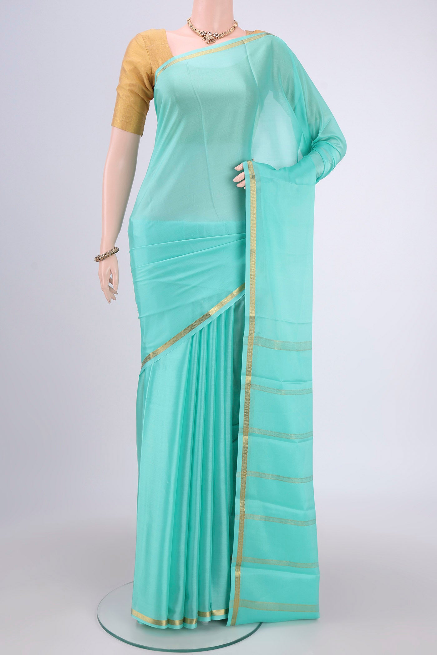 Mint Green Mysore Crepe Saree with Plain Body and Zari Border.  displayed on a mannequin