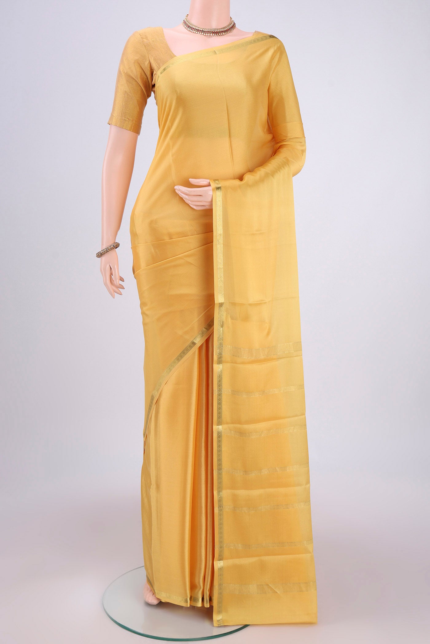 Yellow Mysore Crepe Saree with Plain Body and Zari Border.  displayed on a mannequin