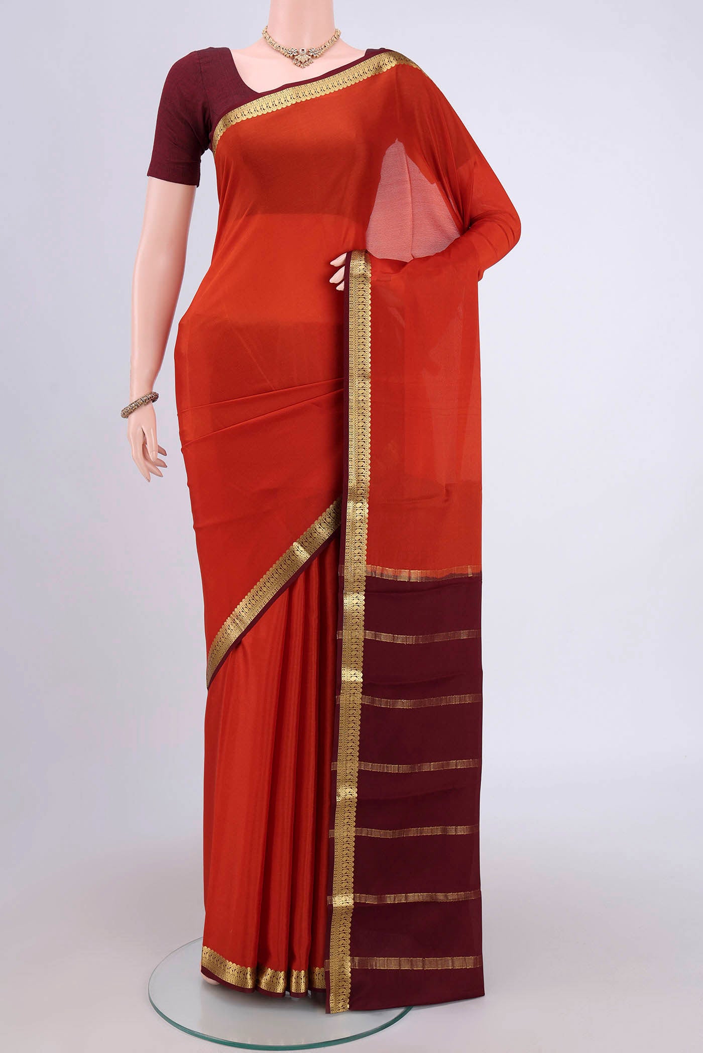 Rust Mysore Crepe Saree with Plain Body and Zari Border.  displayed on a mannequin