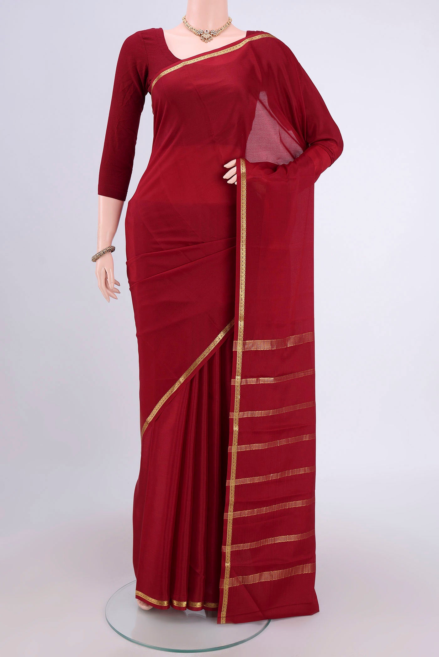 Maroon Mysore Crepe Saree with Plain Body and Zari Border.  displayed on a mannequin