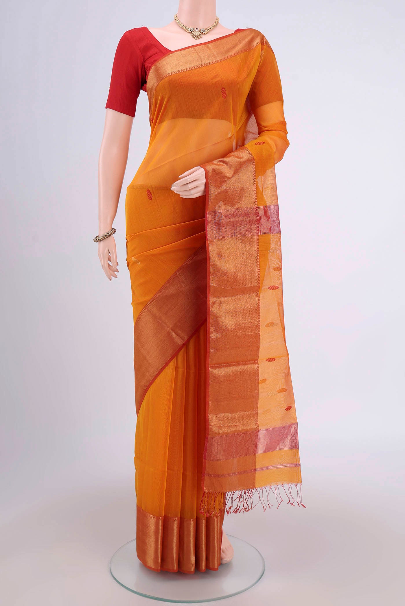 Brick Orange Maheshwari Silk Cotton Saree with Stripes on the body and Zari Border.  displayed on a mannequin