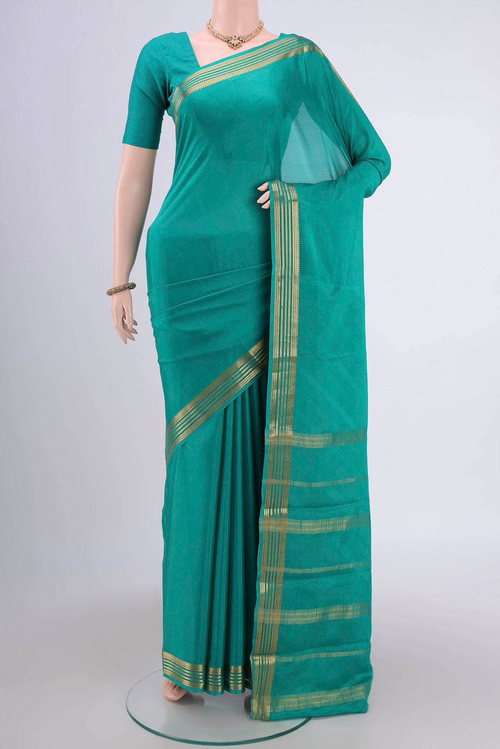 Sea Green Mysore Crepe Saree with Plain Body and Zari Border.  displayed on a mannequin