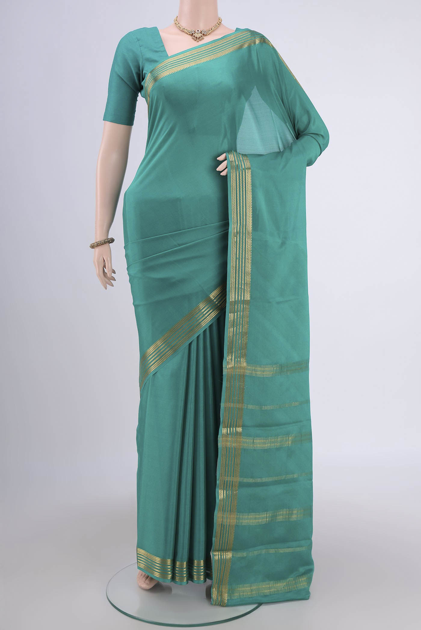 Sea Green Mysore Crepe Saree with Plain Body and Zari Border.  displayed on a mannequin