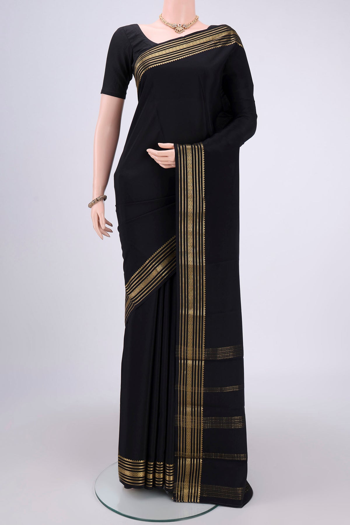Black Mysore Crepe Saree with Plain Body and Zari Border.  displayed on a mannequin