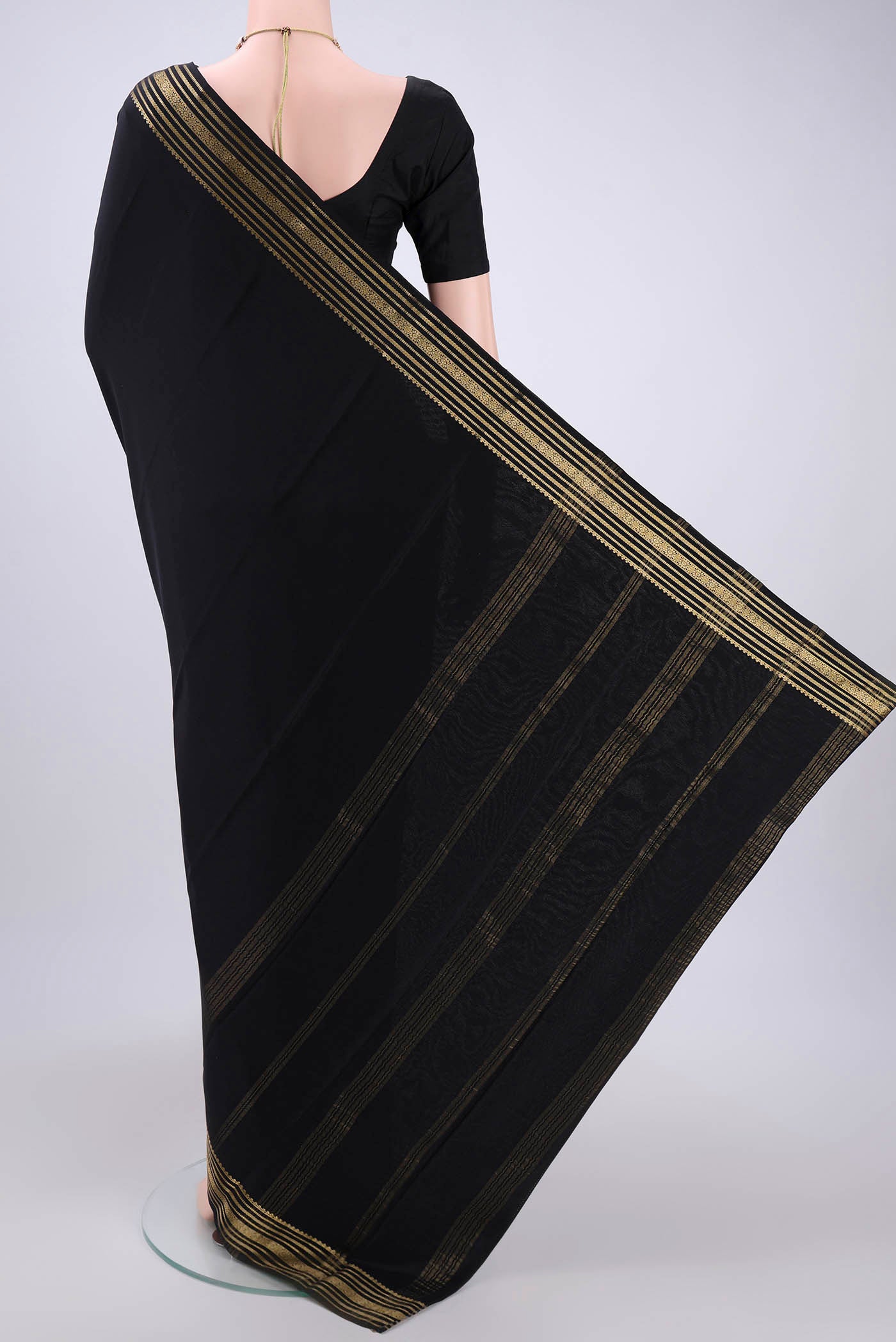 Flat view of Black Mysore Crepe Saree with Plain Body and Zari Border. 