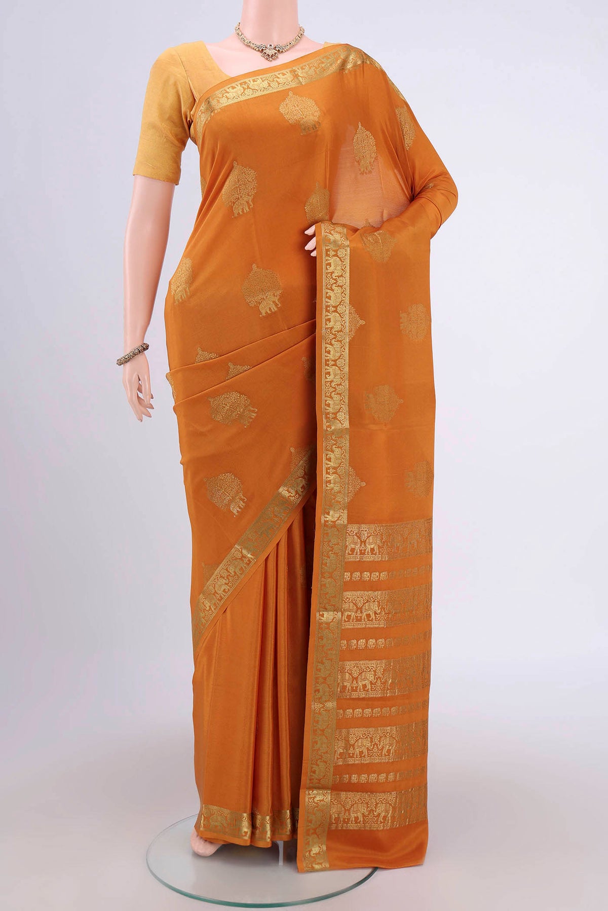 Mustard Mysore Crepe Saree with Zari Butta on the body and Zari Border.  displayed on a mannequin