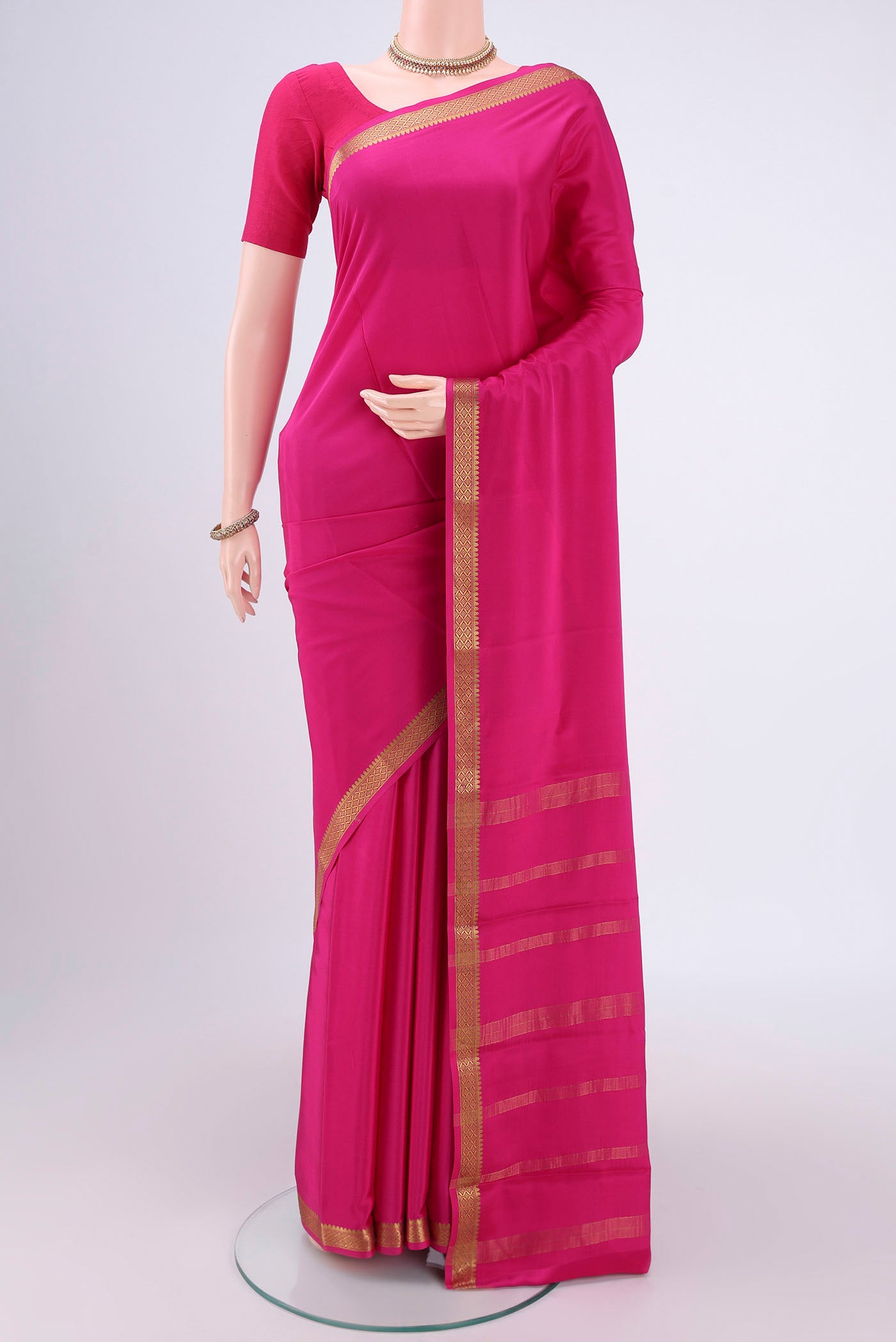 Rani Pink Mysore Crepe Saree with Plain Body and Zari Border.  displayed on a mannequin
