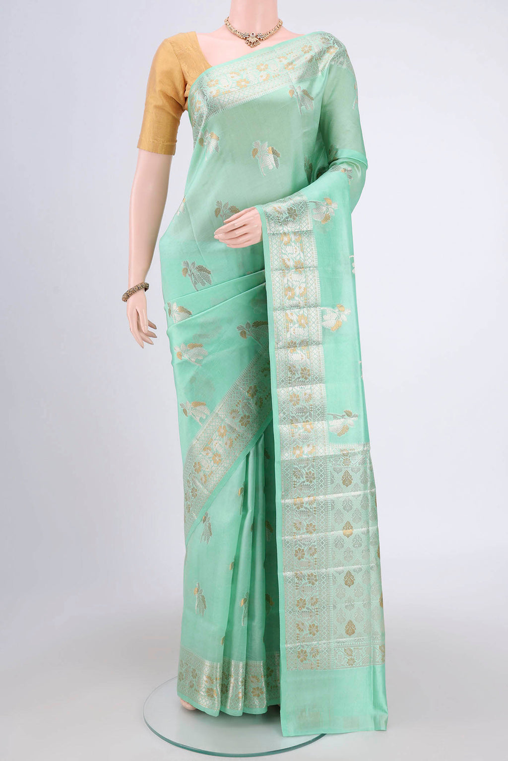 Mint Green Banarasi Raw Silk Saree with Zari Butta on the body and Zari Border.  displayed on a mannequin