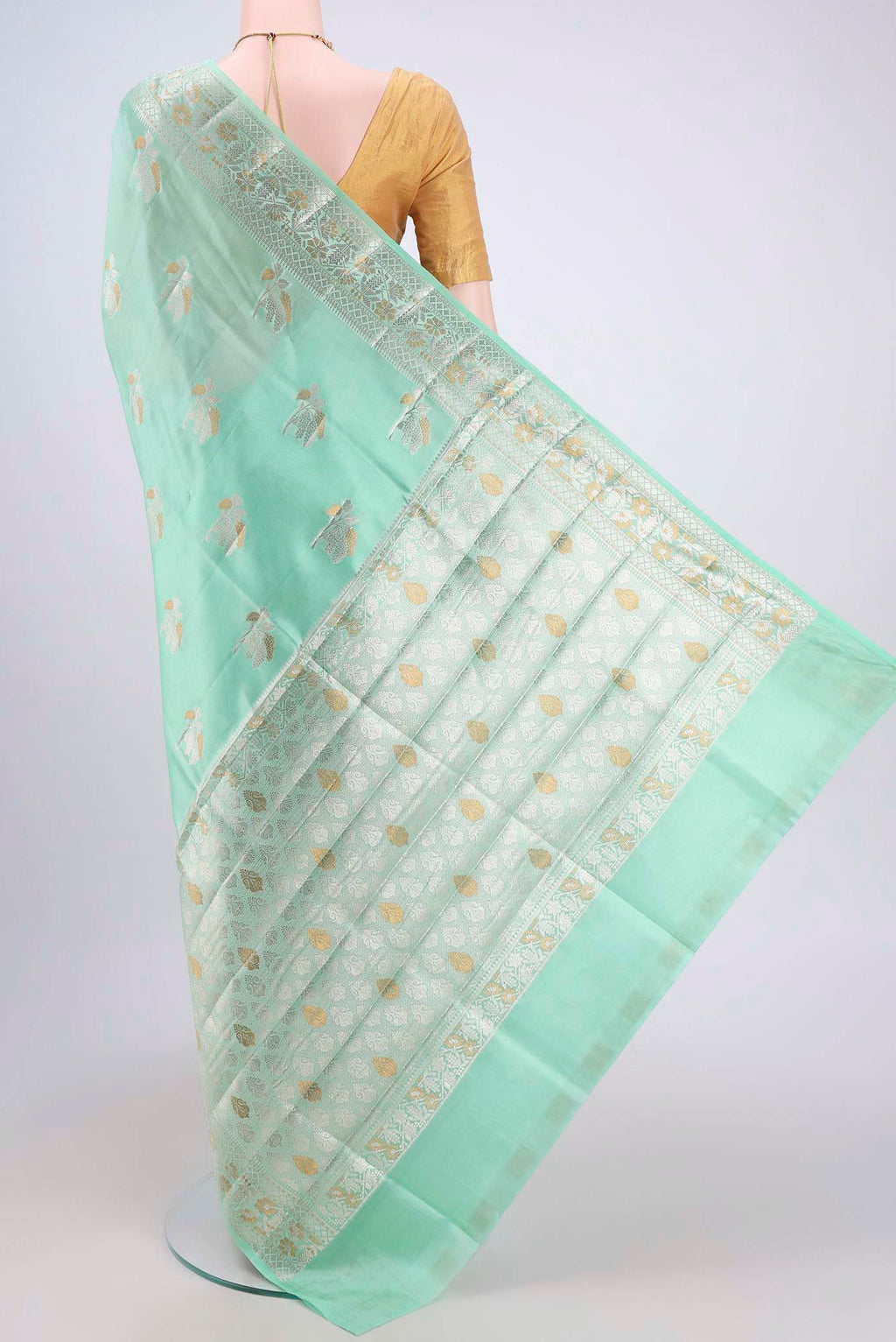Flat view of Mint Green Banarasi Raw Silk Saree with Zari Butta on the body and Zari Border. 