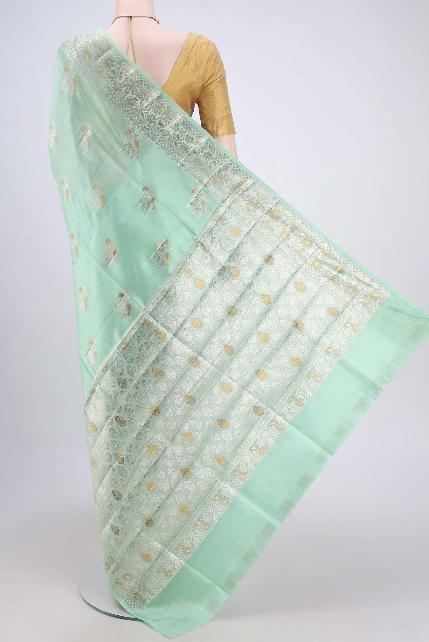 Flat view of Mint Green Banarasi Raw Silk Saree with Zari Butta on the body and Zari Border. 