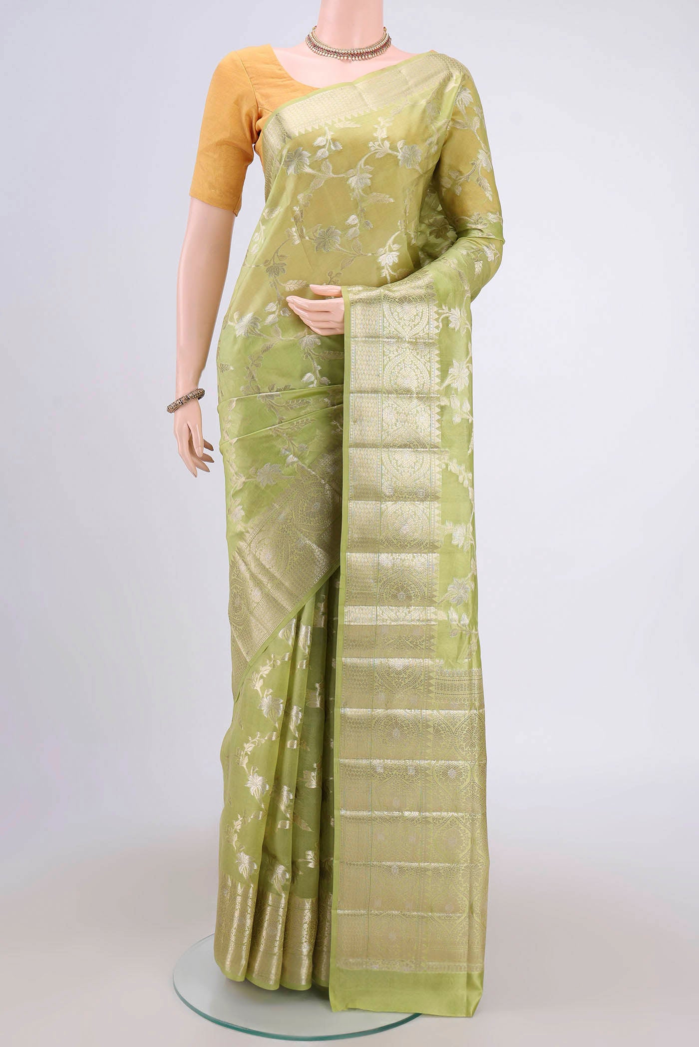 Light Green Banarasi Raw Silk Saree with Zari Butta on the body and Zari Border.  displayed on a mannequin