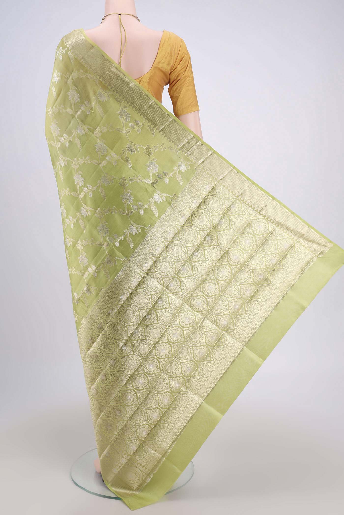 Flat view of Light Green Banarasi Raw Silk Saree with Zari Butta on the body and Zari Border. 
