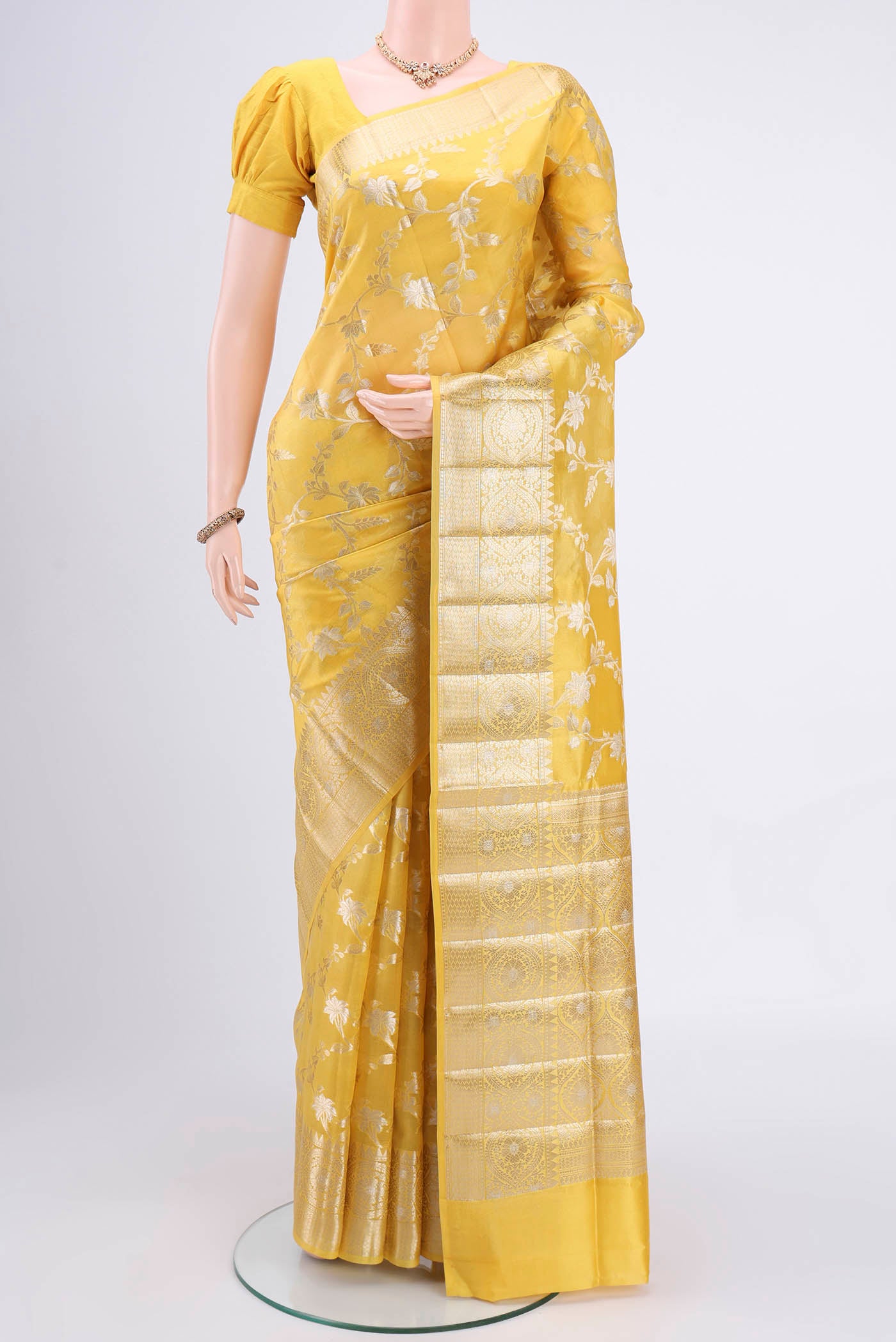 Yellow Banarasi Raw Silk Saree with Zari Butta on the body and Zari Border.  displayed on a mannequin