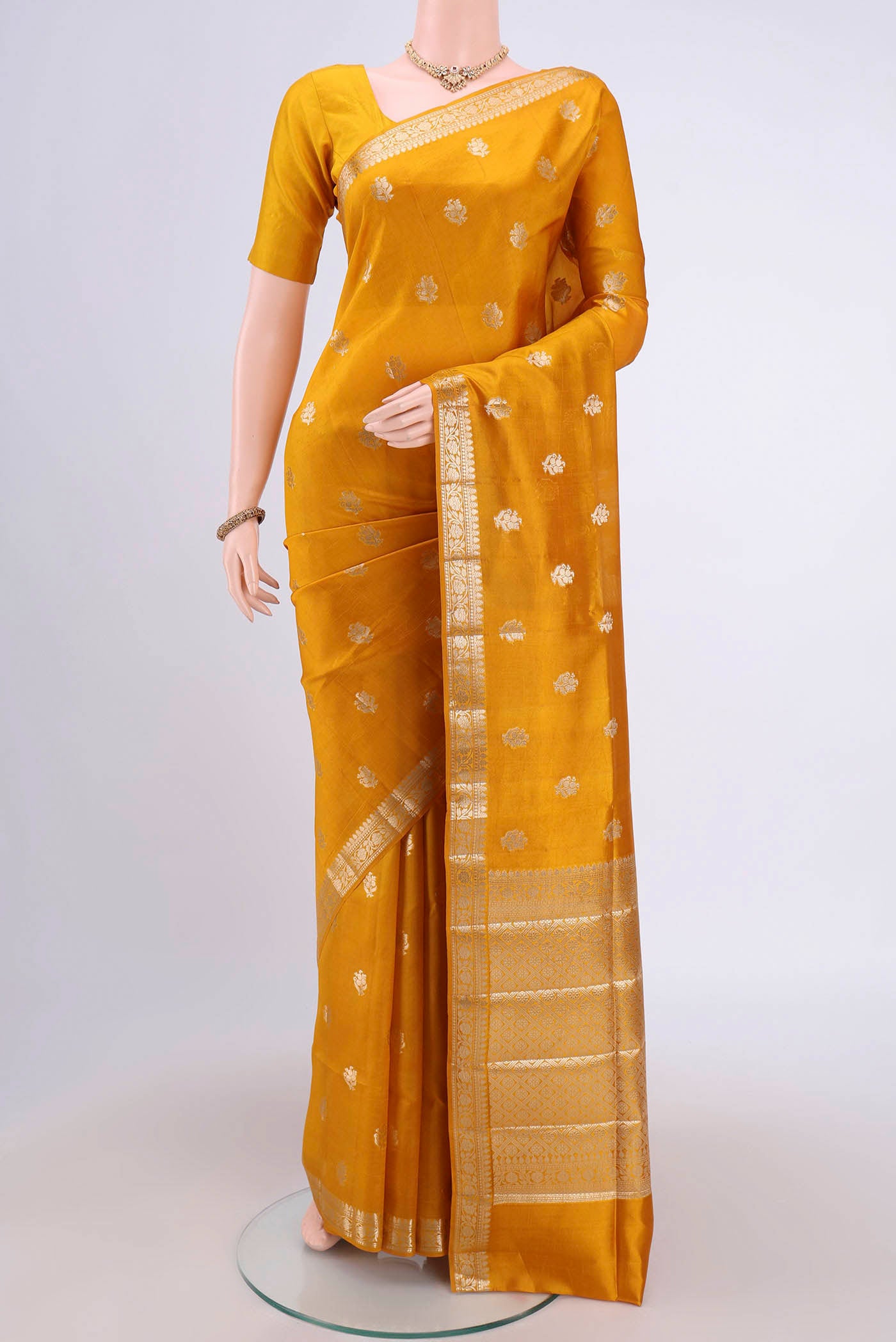 Mustard Banarasi Raw Silk Saree with Zari Butta on the body and Zari Border.  displayed on a mannequin