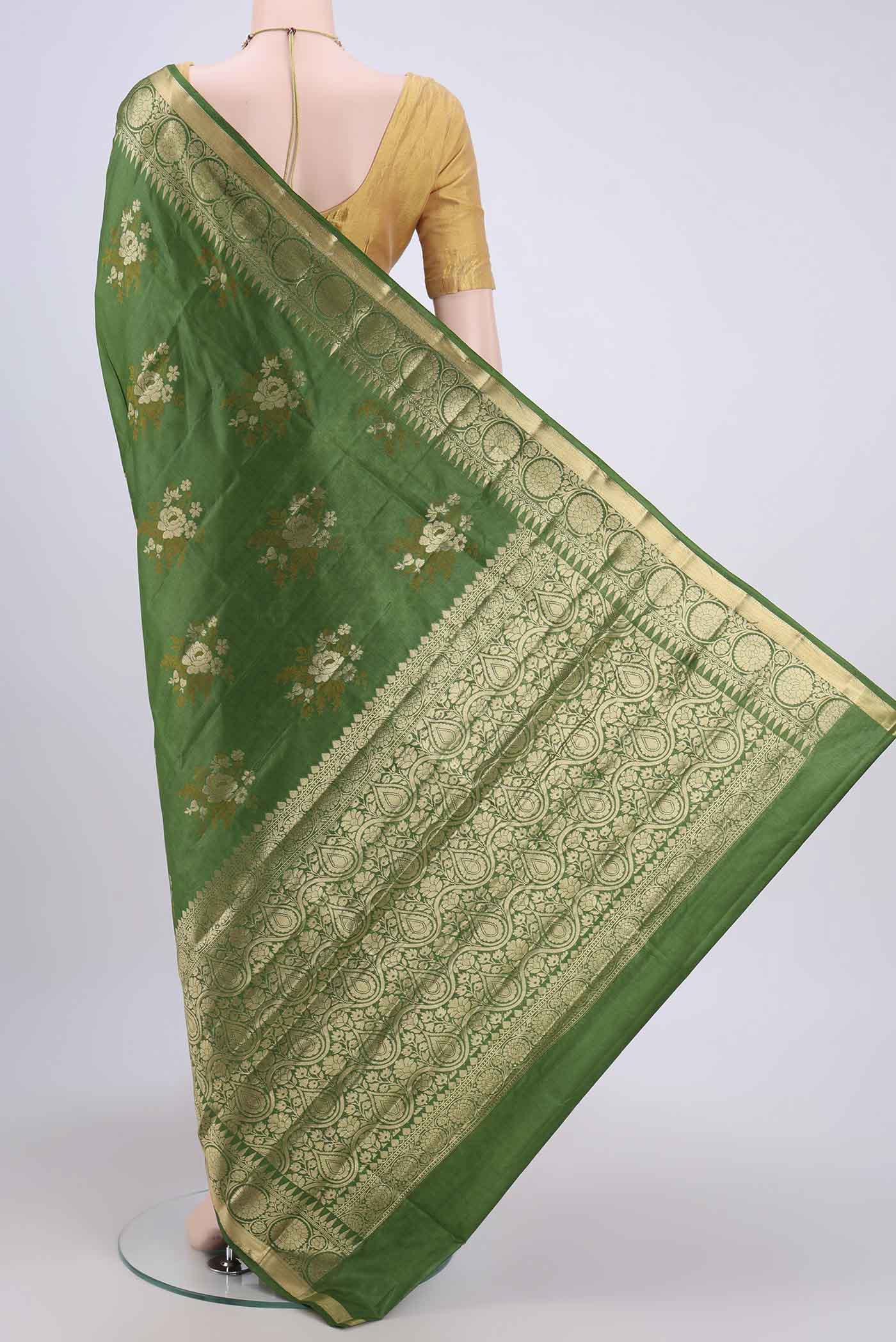 Flat view of Green Banarasi Tussar Silk Saree with Zari Butta on the body and Zari Border. 