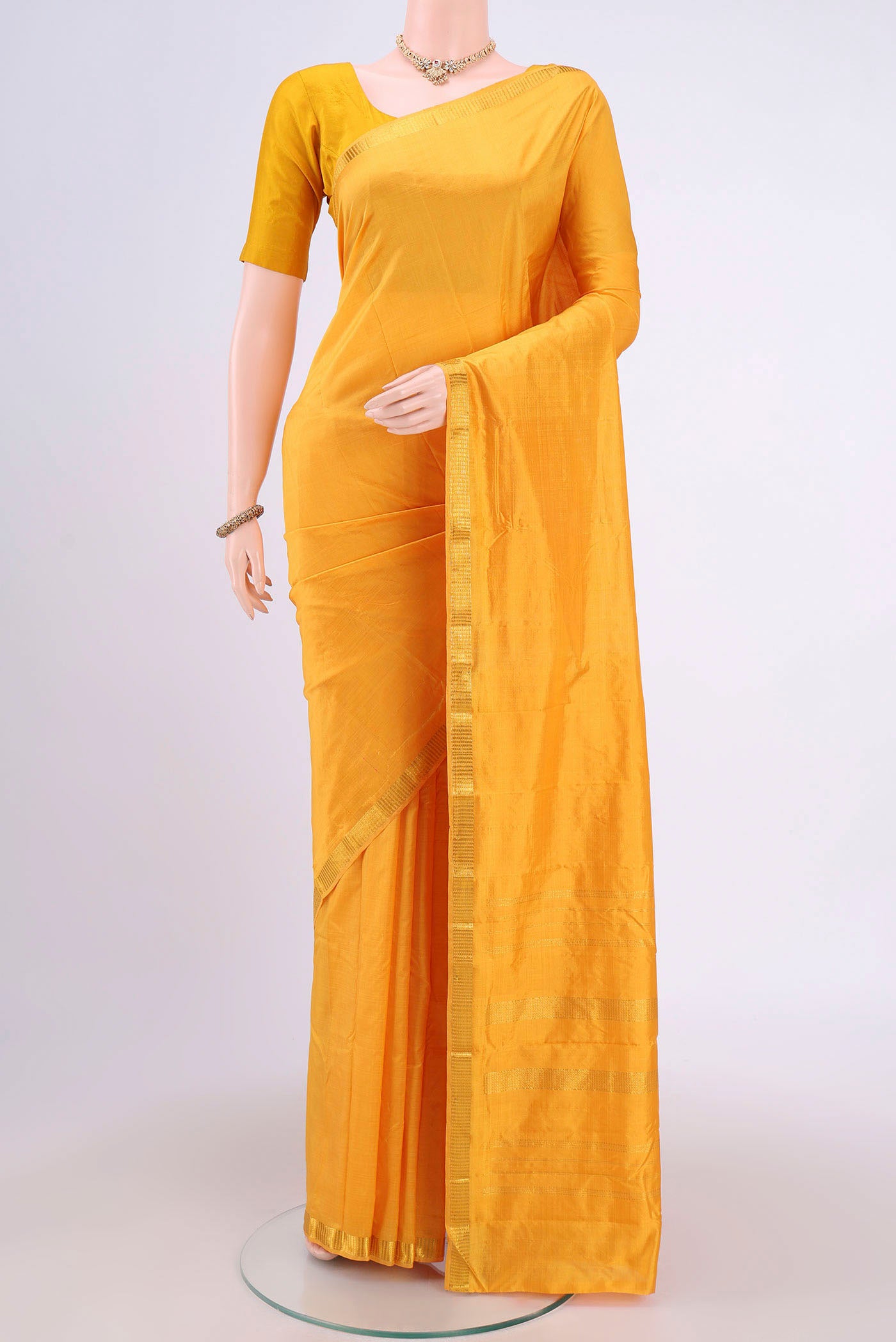 Yellow Kanchipuram Saree with Plain Body and Zari Border.  displayed on a mannequin