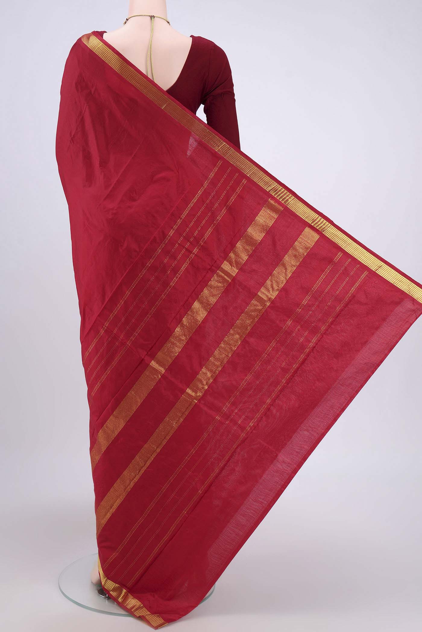 Flat view of Maroon Kanchipuram Saree with Plain Body and Zari Border. 