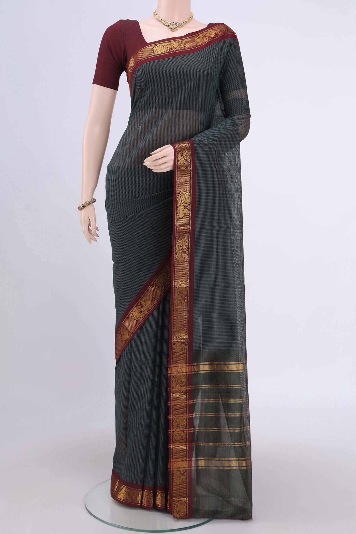 Bottle Green Kanchi Cotton Saree with Stripes on the body and Zari Border.  displayed on a mannequin