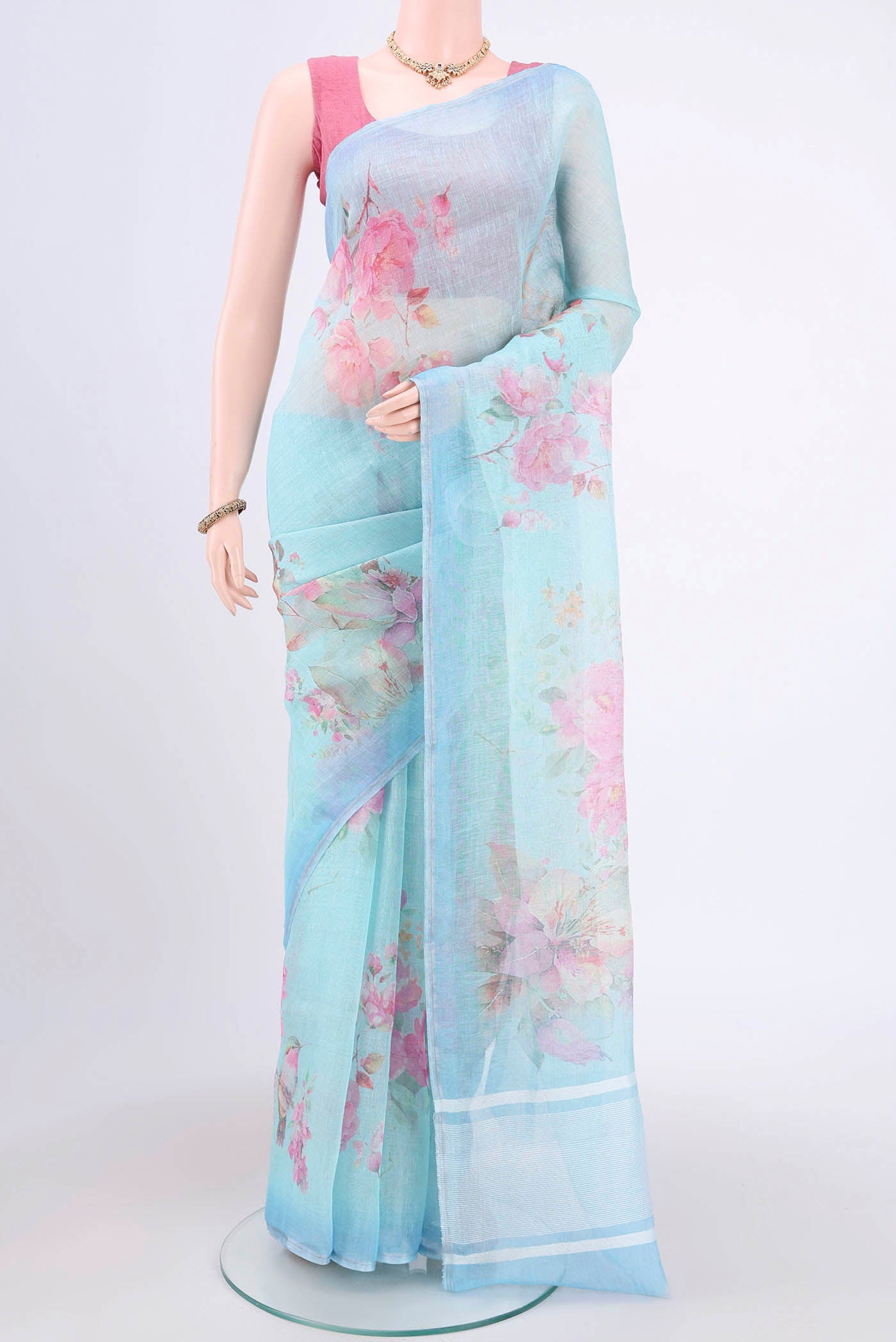 Mint Green Linen Cotton Saree with Floral Print on the body and Zari Border.  displayed on a mannequin