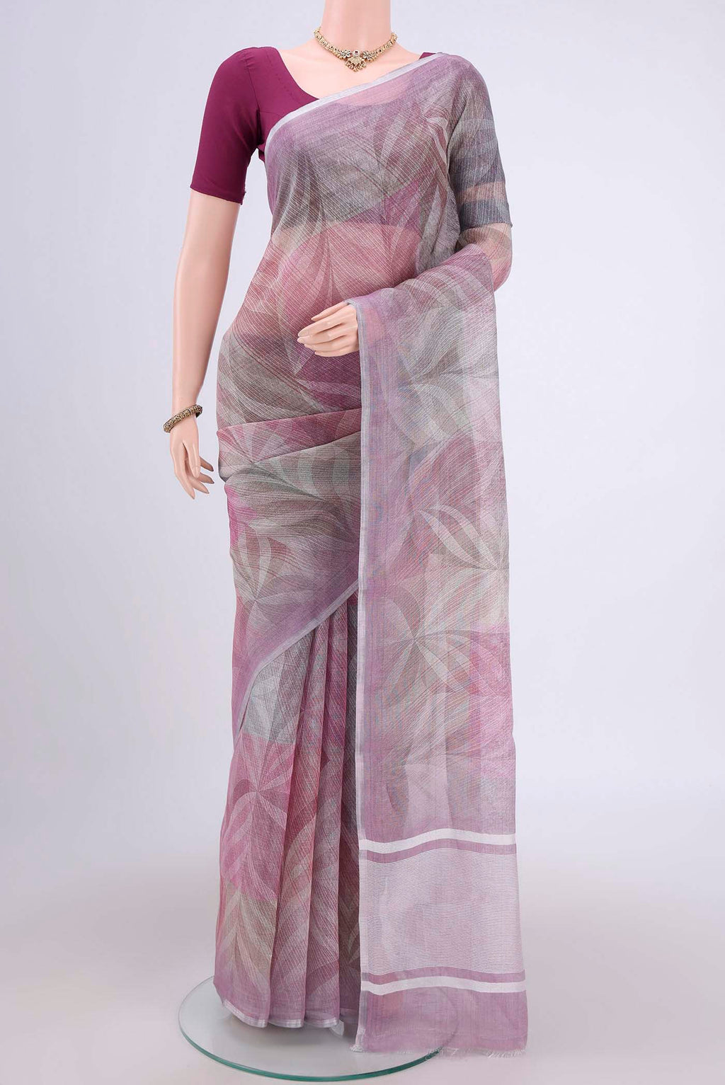 Mauve Linen Cotton Saree with Floral Print on the body and Zari Border.  displayed on a mannequin