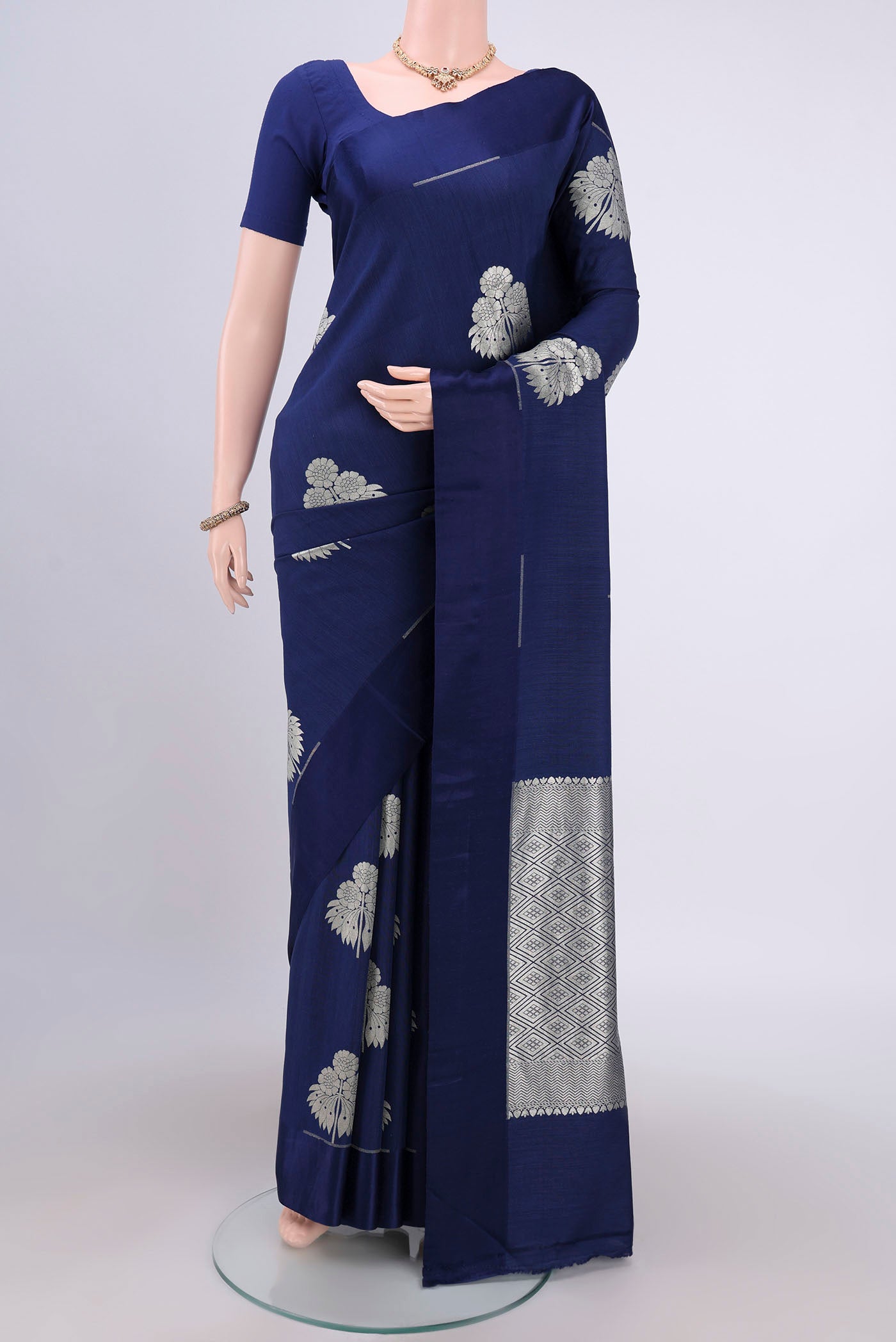 Navy Blue Soft Silk Saree with Zari Butta on the body and Without Border.  displayed on a mannequin