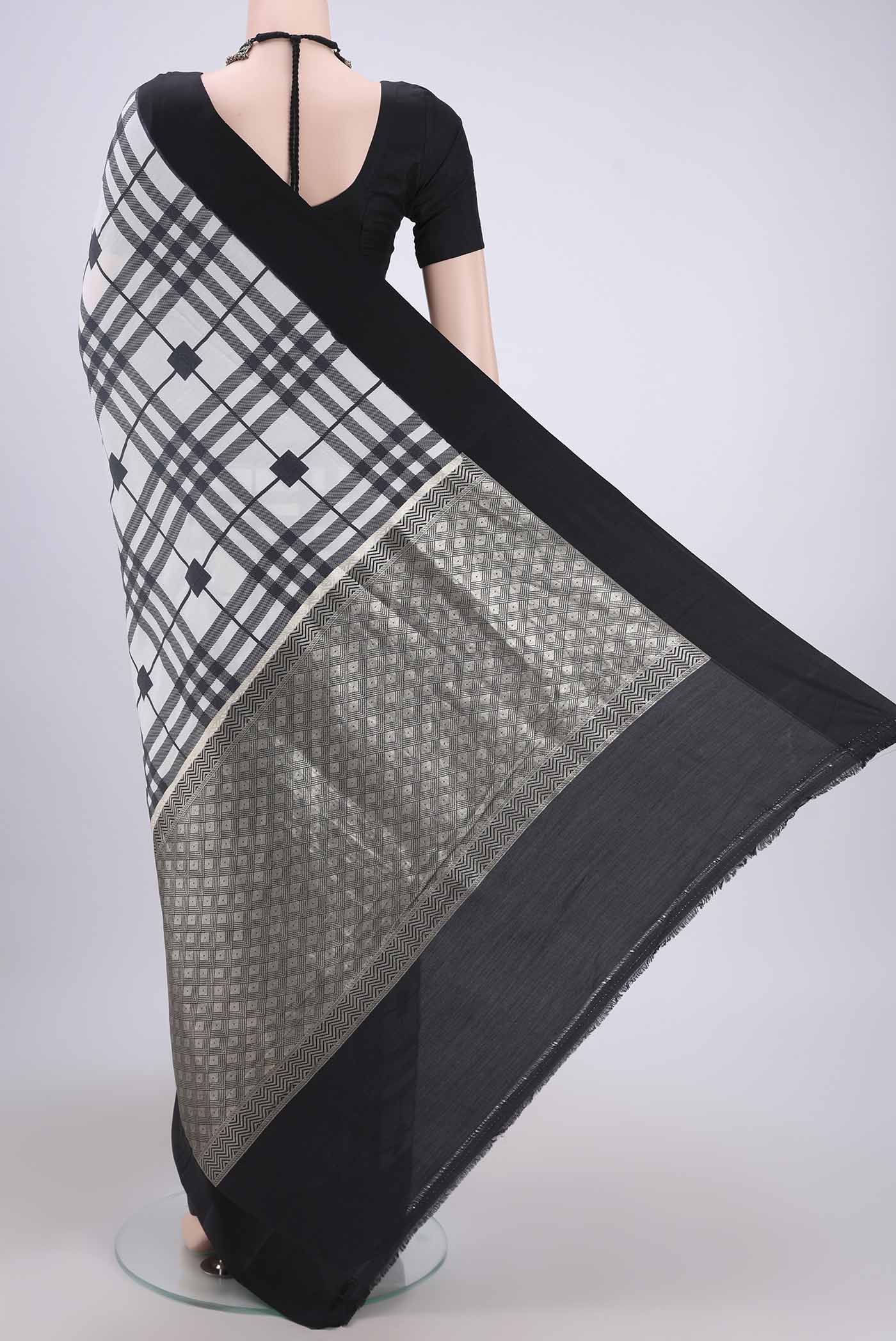 Flat view of White Soft Silk Saree with Checked design on the body and Without Border. 