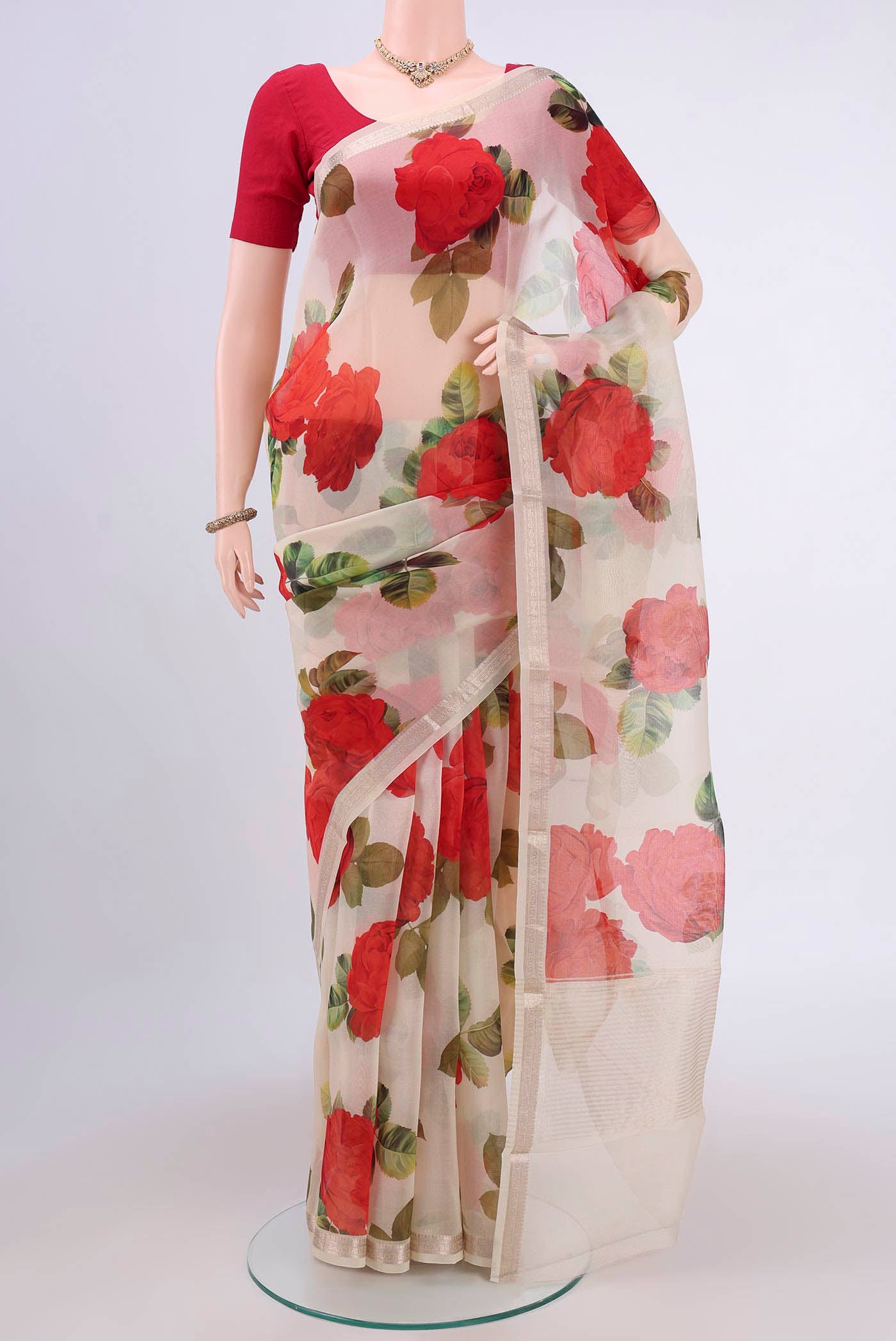 Off White Organza Silk Saree with Floral Print on the body and Zari Border.  displayed on a mannequin