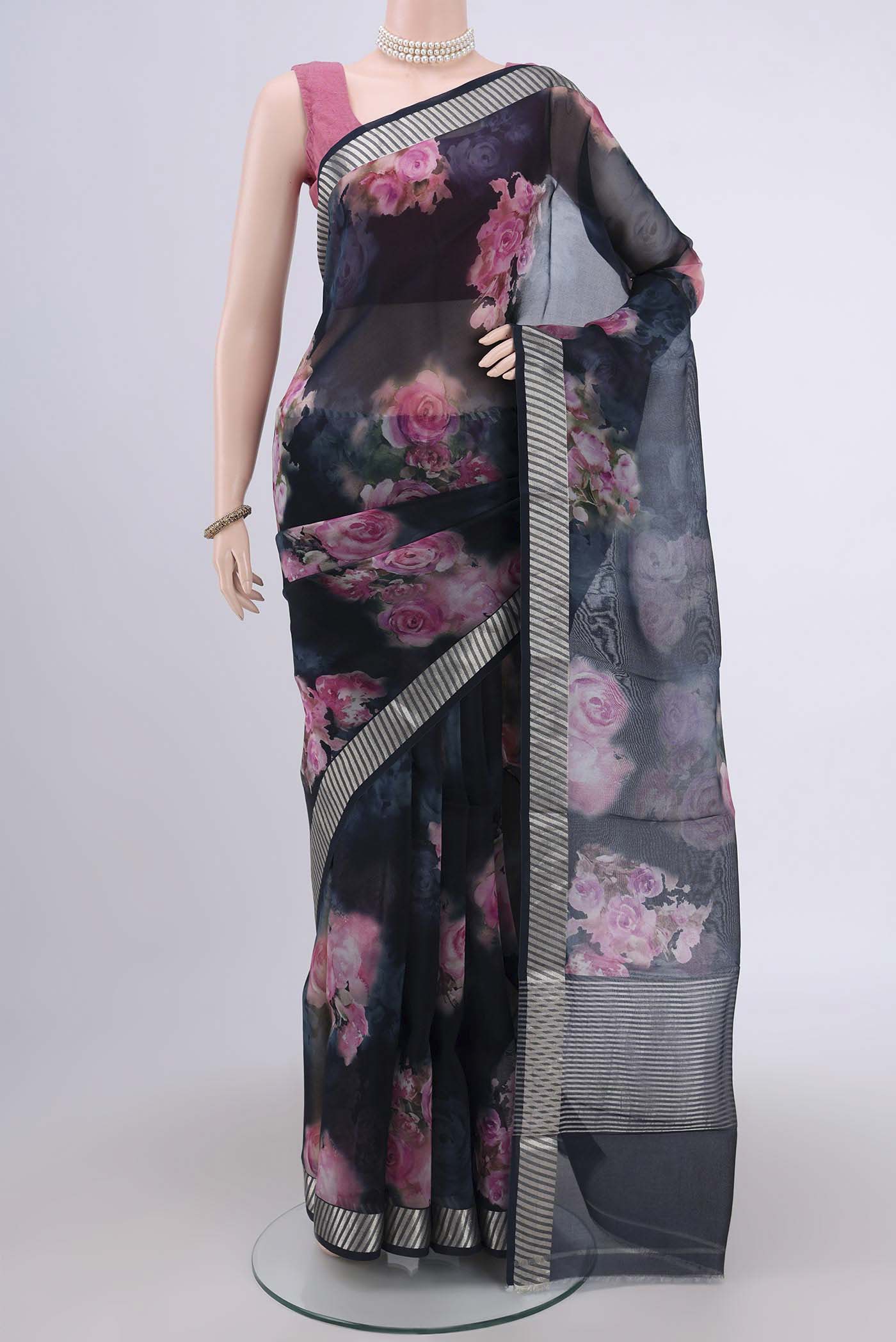 Navy Blue Organza Silk Saree with Floral Print on the body and Zari Border.  displayed on a mannequin