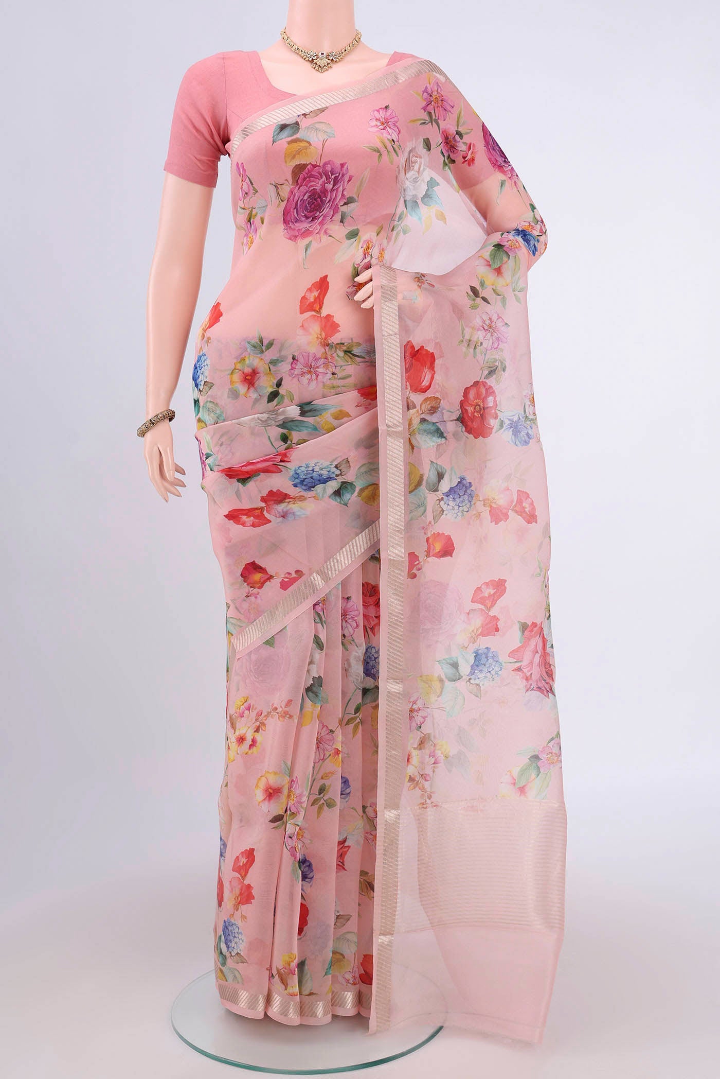 Rani Pink Organza Silk Saree with Floral Print on the body and Zari Border.  displayed on a mannequin