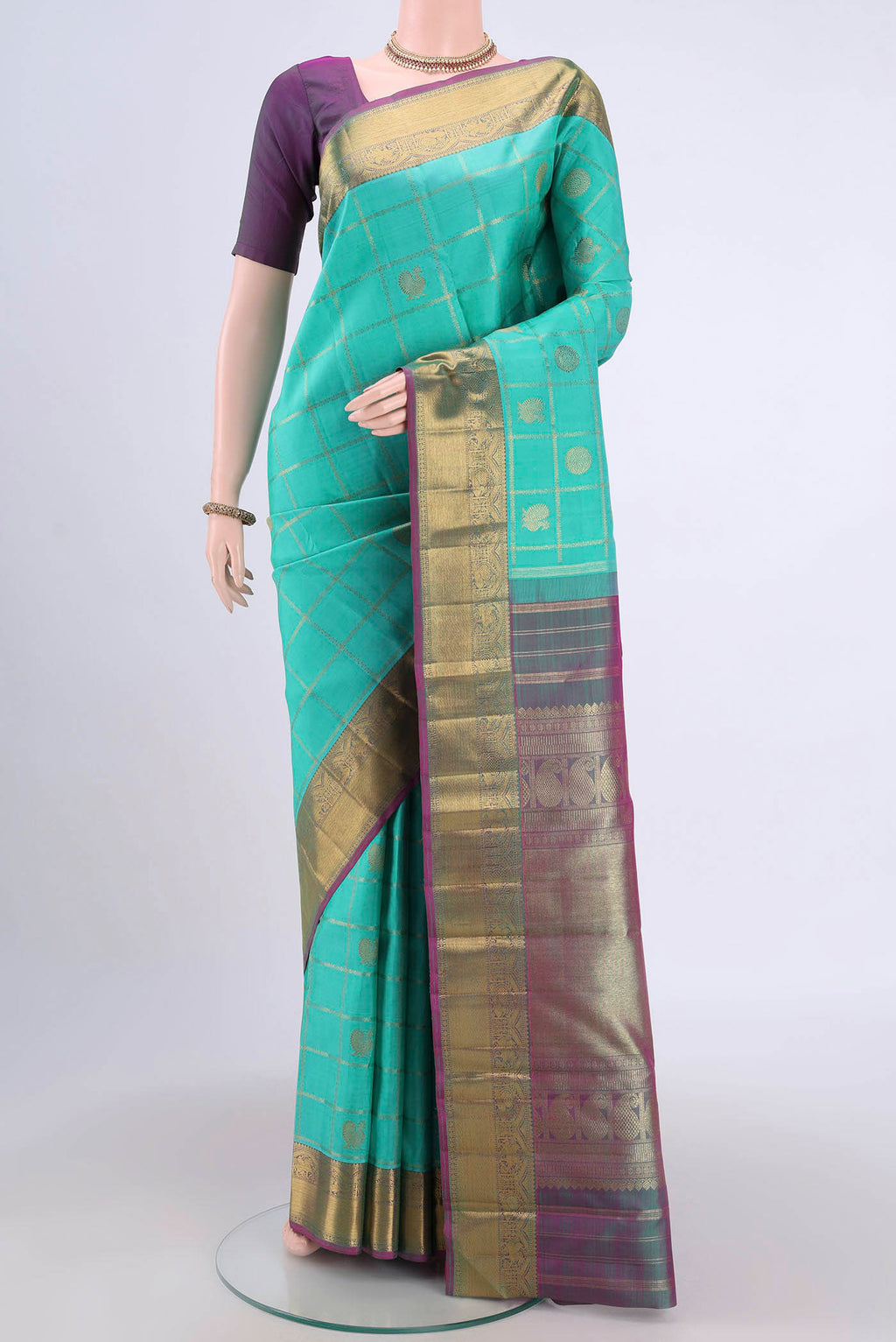 Turquoise Kanjivaram Saree with Zari Butta on the body and Zari Border.  displayed on a mannequin