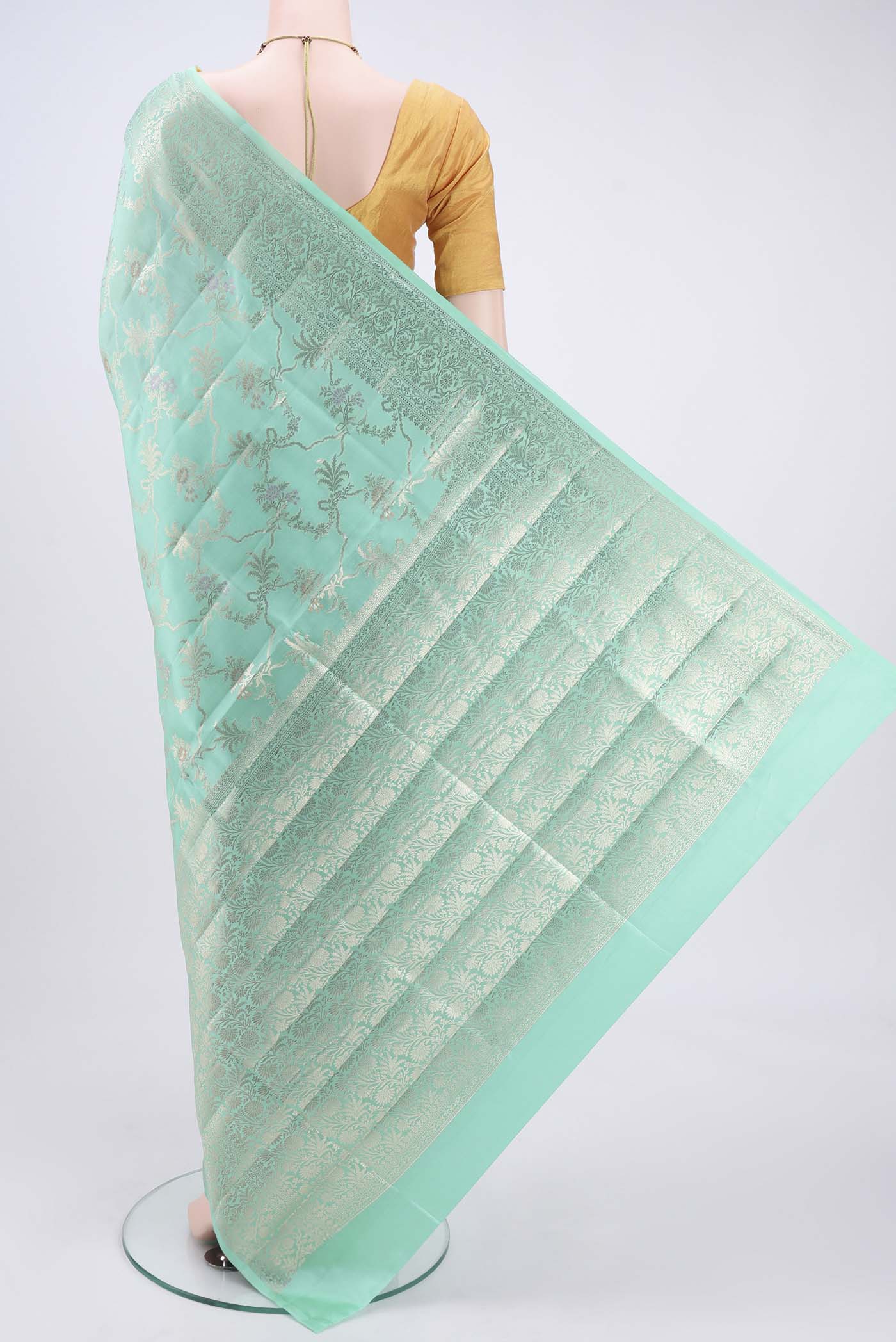 Flat view of Mint Green Banarasi Raw Silk Saree with Zari Butta on the body and Zari Border. 
