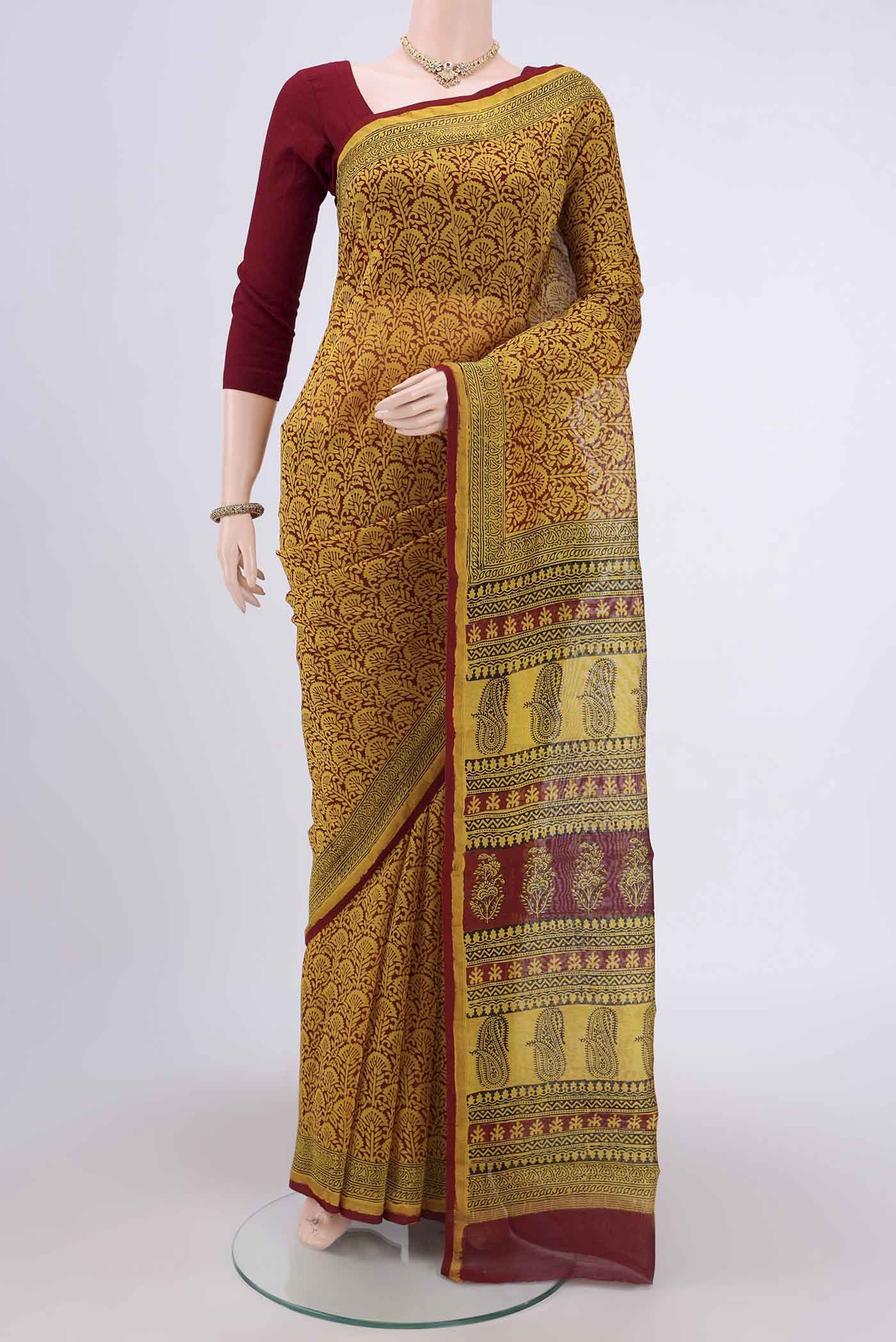 Mustard Maheshwari Silk Cotton Saree with Printed design on the body and Zari Border.  displayed on a mannequin
