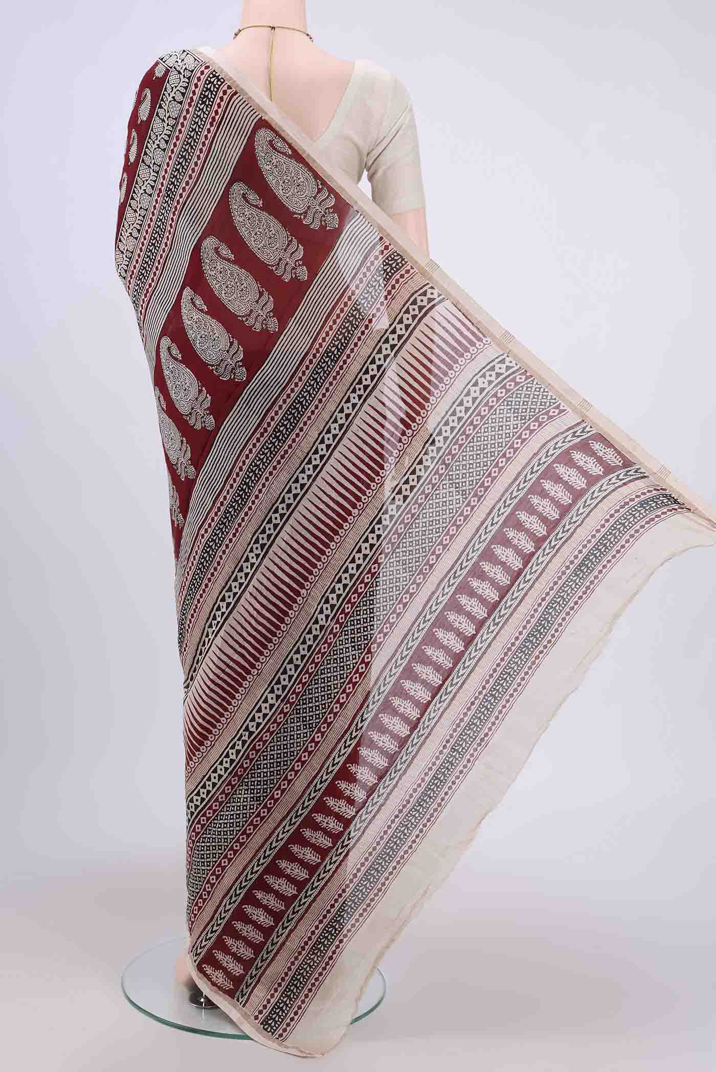 Flat view of Maroon Maheshwari Silk Cotton Saree with Printed design on the body and Zari Border. 