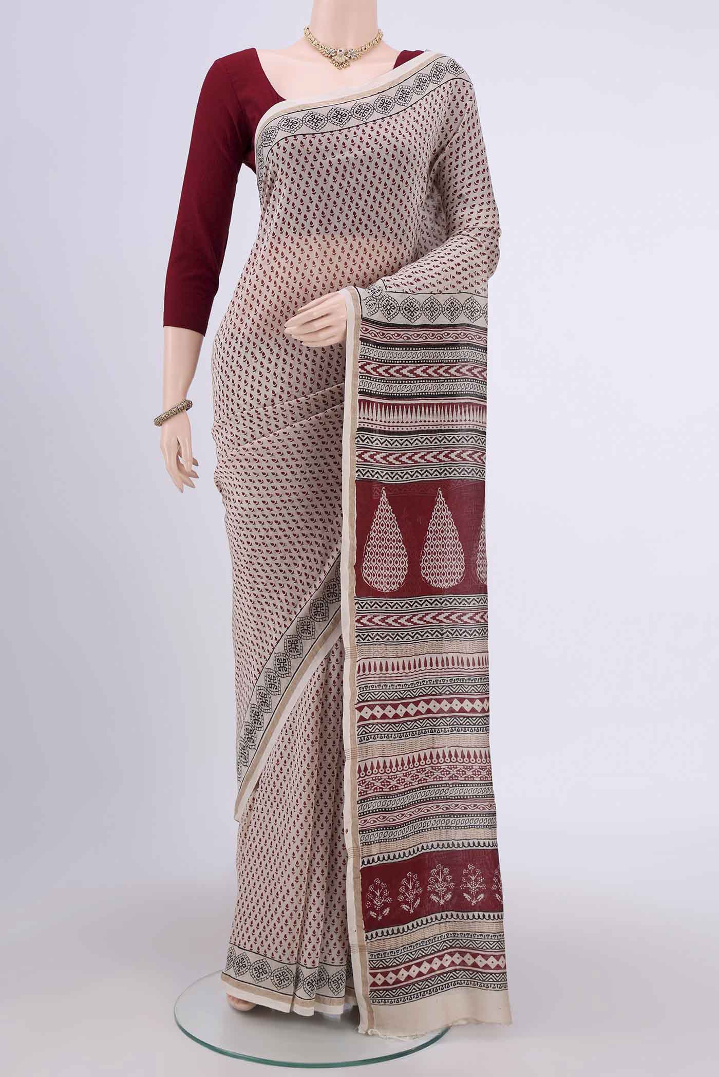 Off White Maheshwari Silk Cotton Saree with Printed design on the body and Zari Border.  displayed on a mannequin