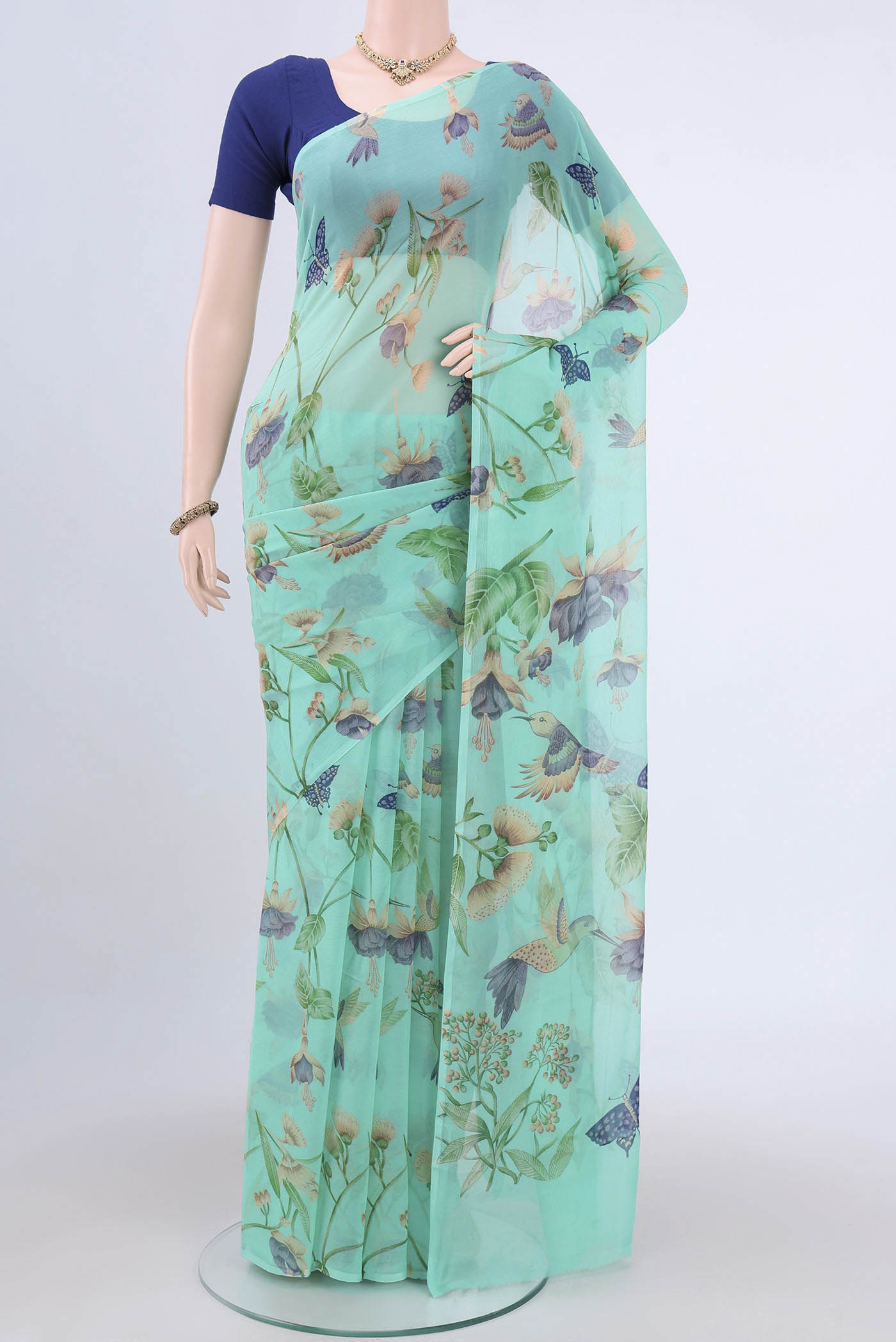 Turquoise Mysore Crepe Saree with Floral Print on the body and Zari Border.  displayed on a mannequin
