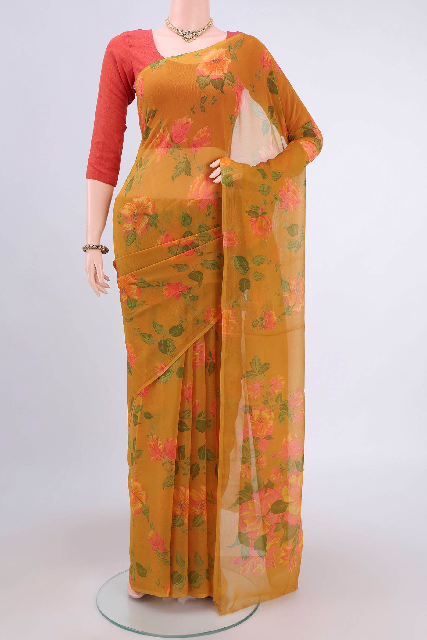 Mustard Mysore Crepe Saree with Floral Print on the body and Zari Border.  displayed on a mannequin