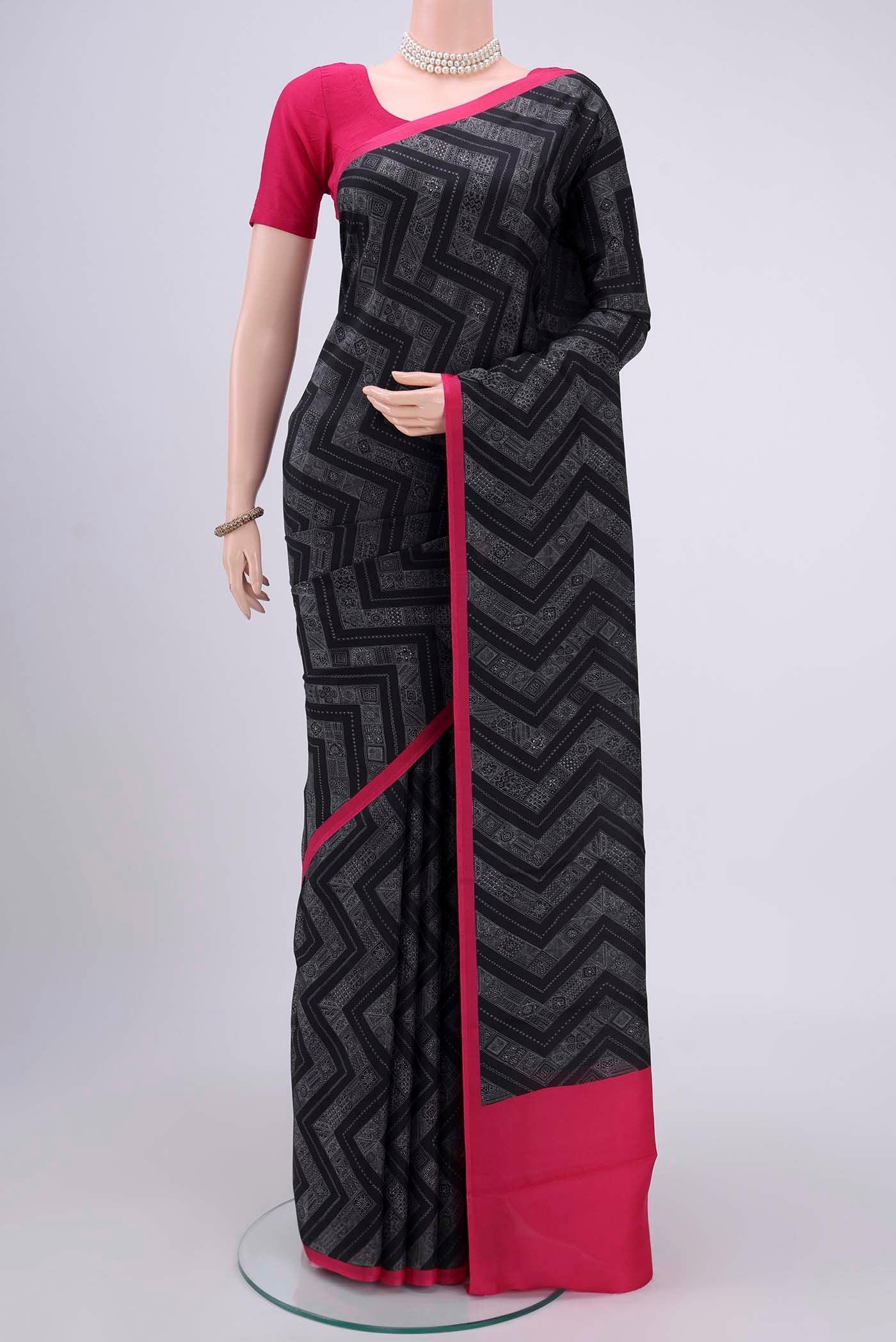 Black Printed Silk Saree with Printed design on the body and Plain Border.  displayed on a mannequin