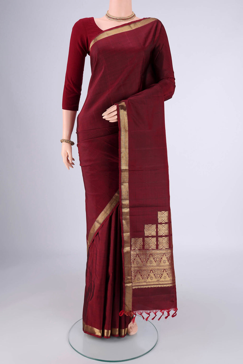 Pure Silk Pure Zari Maroon Kanjivaram Saree with Plain Body and Zari Border.  displayed on a mannequin